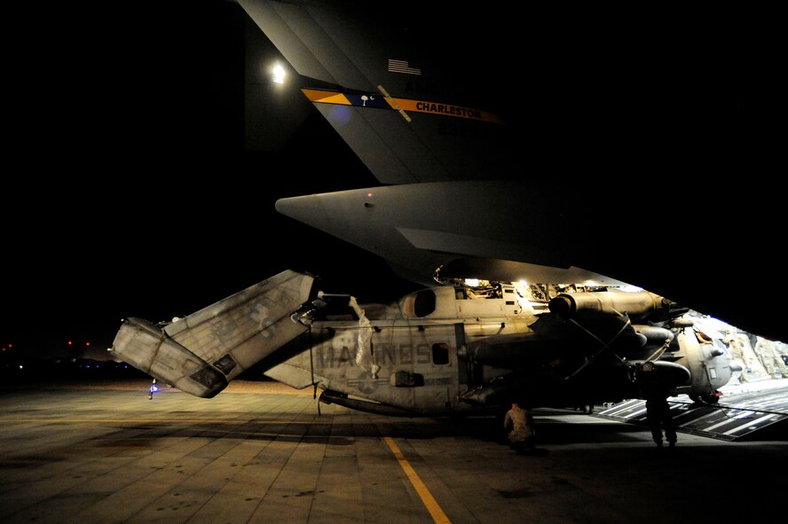 U.S. Marines from the 26th Marine Expeditionary Unit from Marine Corps Air Station Cherry Point, N.C., along with U.S. Air Force members assigned to the 14th Airlift Squadron, Joint Base Charleston, S.C. offload a CH-53E Super Stallion from a C-17 Globemaster III at Camp Bastion, Afghanistan, on Aug. 22, 2010.  The helicopter is one of four that will be used to supplement U.S. military rescue and relief efforts in the flood affected areas of Pakistan.  (U.S. Air Force photo by Staff Sgt. Kamaile O. Long)