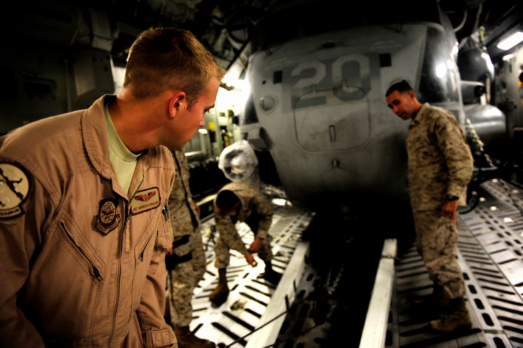 U.S. Air Force Airman First Class Andrew Poulisse, a loadmater assigned to the 14th Airlift Squadron, Joint Base Charleston, S.C., offloads a CH-53E Super Stallion with the help of U.S. Marines assigned to the 26th Marine Expeditionary Unit from Marine Corps Air Station Cherry Point, N.C. at Camp Bastion, Afghanistan on August 22, 2010. The helicopter is one of four that will be used to supplement U.S. military rescue and relief efforts in the flood affected areas of Pakistan.  (U.S. Air Force photo by Staff Sgt. Kamaile O. Long)