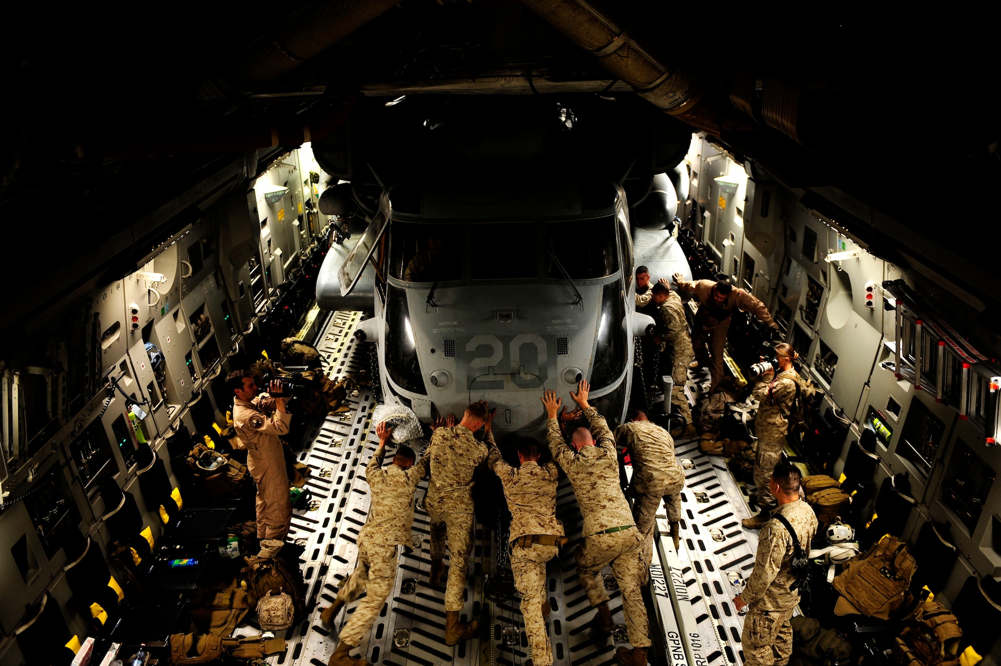 U.S. Marines assigned to the 26th Marine Expeditionary Unit from Marine Corps Air Station Cherry Point, N.C., along with U.S. Air Force members assigned to the 14th Airlift Squadron, Joint Base Charleston, S.C. offload a CH-53E Super Stallion from a C-17 Globemaster III at Camp Bastion, Afghanistan, Aug. 22, 2010.  The helicopter is one of four that will be used to supplement U.S. military rescue and relief efforts in the flood affected areas of Pakistan.  (U.S. Air Force photo by Staff Sgt. Kamaile O. Long/Not Reviewed)