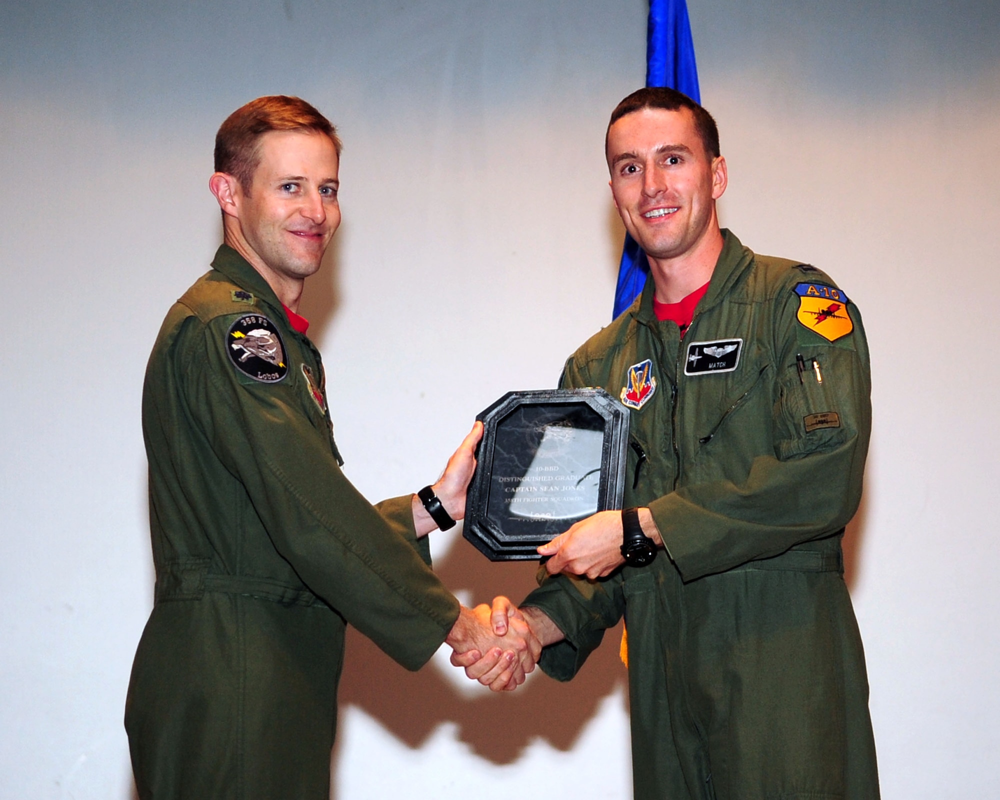 Lt. Col. Scott Campbell (left), 358th Fighter Squadron commander, presents the distinguished graduate award to Capt. Sean Jones during the graduation ceremony for A-10C Pilot Initial Qualification Course class 10-BBD here Aug. 20, 2010. In the class of 12 graduating pilots, Captain Jones was jointly chosen as the DG by the flight commanders, squadron director of operations and squadron commander. (U.S. Air Force photo/Airman 1st Class Jerilyn Quintanilla)
