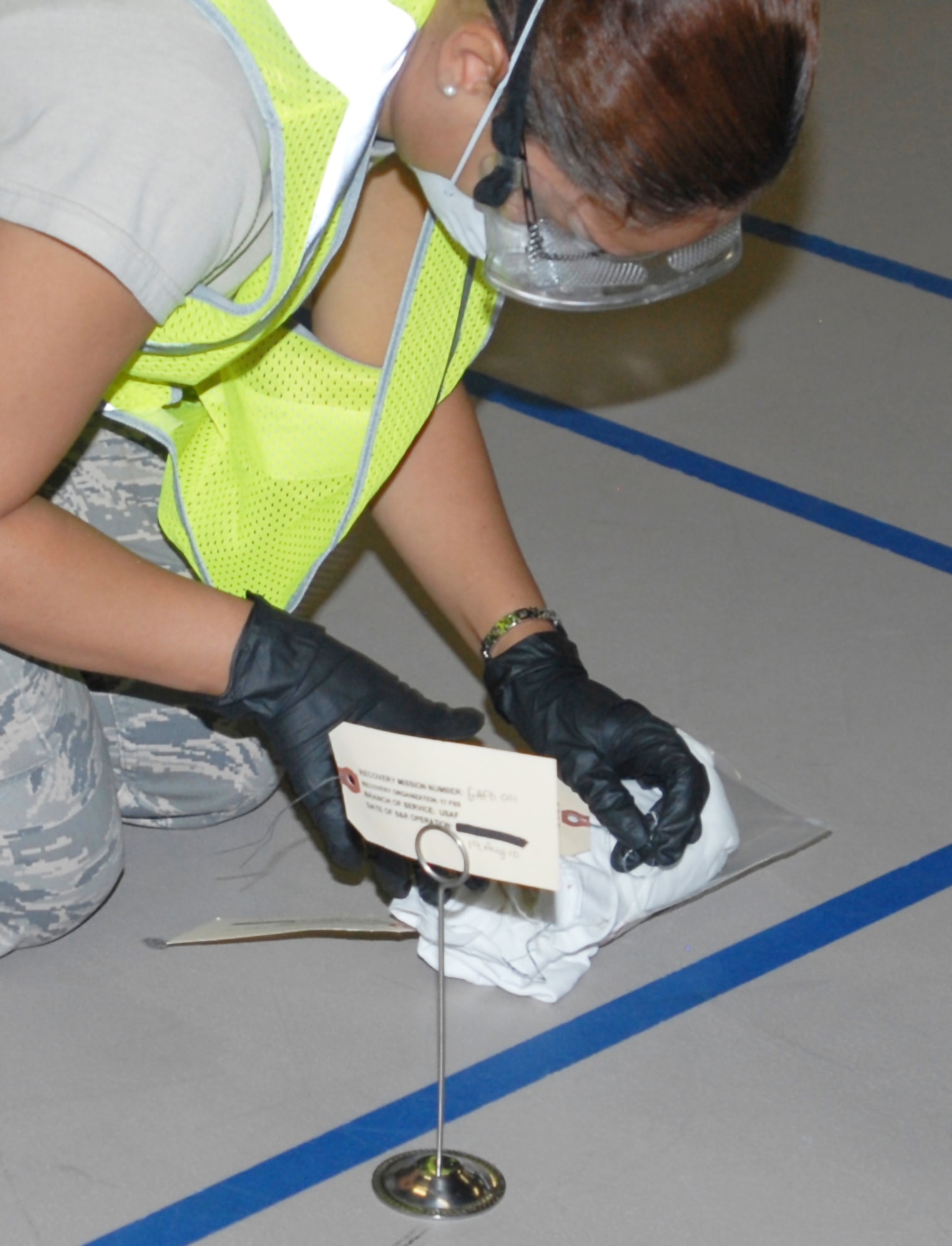 Search and Recovery team member, Senior Airman Laura Garcia, 17th Force Support Squadron, tags personal effects at the Carswell Field House during the active shooter exercise Aug. 19. (U.S. Air Force photo/Staff Sgt. Laura McFarlane)