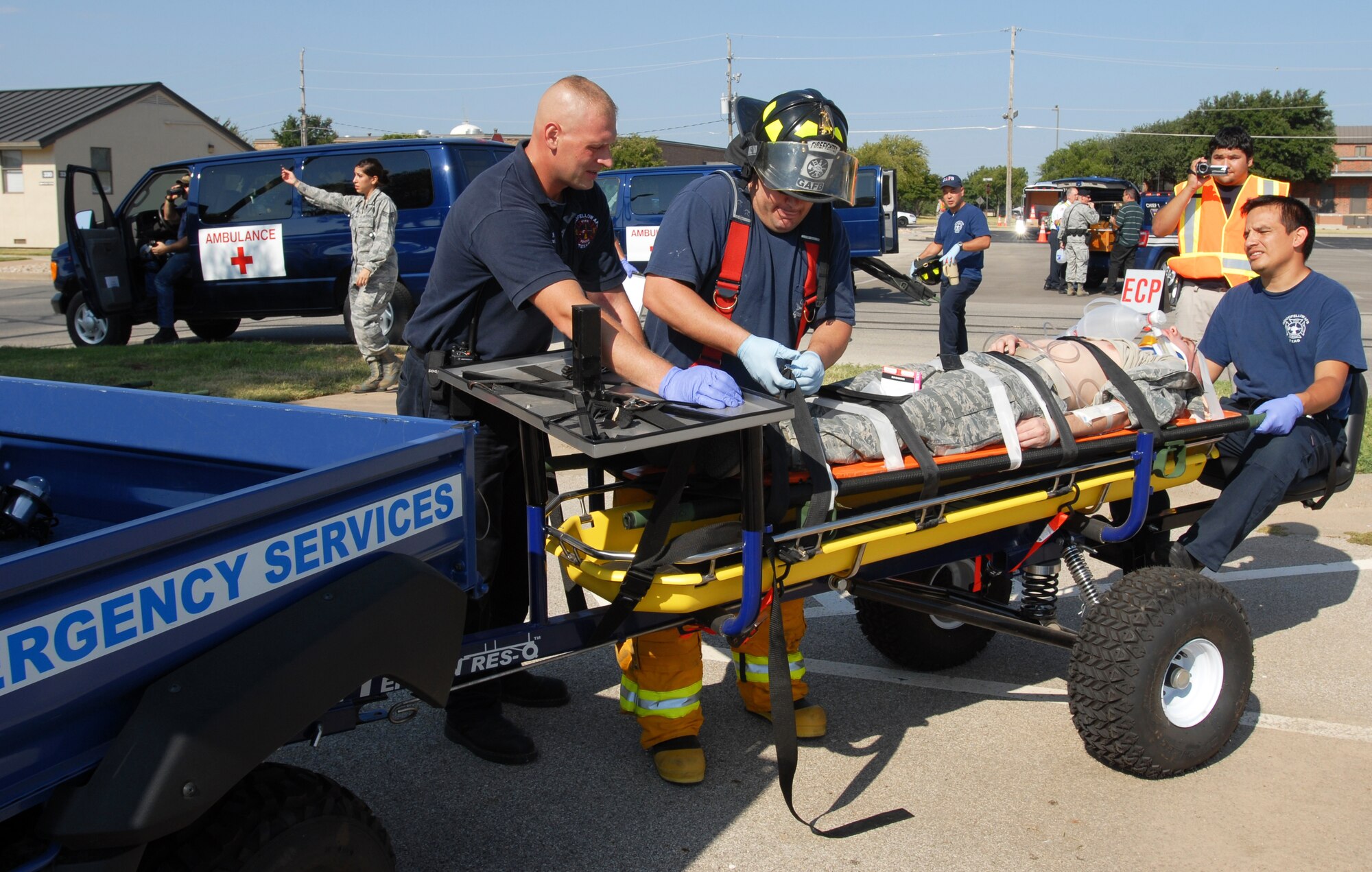 From left: First Responsers Justin Kammer, Kevin Frierson and Miguel Chacon, Goodfellow Air Force Base firefighters, attend to a patient while transporting him on a rescue trailer to an AirMed flight during the active shooter exercise Aug. 19. (U.S. Air Force photo/Lou Czarnecki)