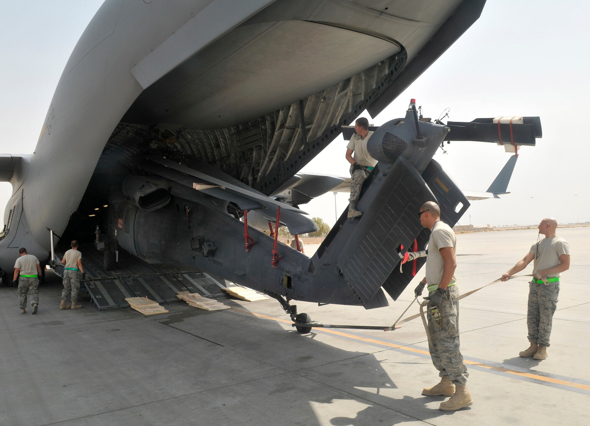 Airmen of the 332nd Expeditionary Aircraft Maintenance Squadron 64th Expeditionary Helicopter Maintenance Unit, off-load a HH-60 Pave Hawk helicopter from a C-17 Globemaster III cargo aircraft Aug. 12, 2010, Joint Base Balad, Iraq. The HH-60 folds to fit the confines of a C-17. (U.S. Air Force photo/Staff Sgt. Phillip Butterfield)