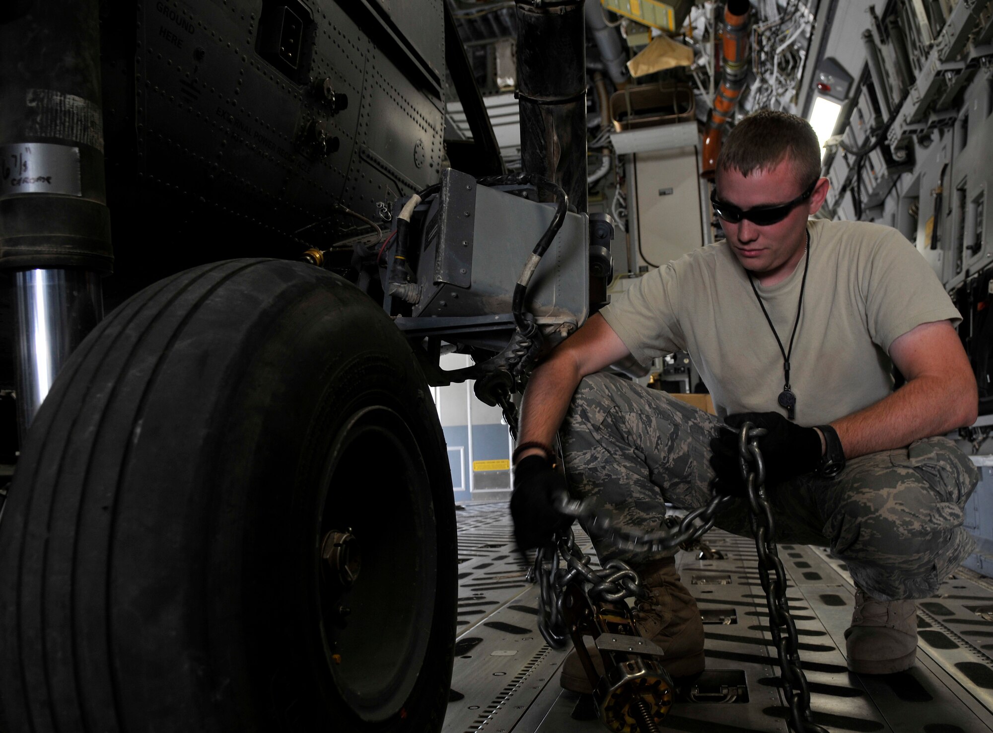 Staff Sgt. David Bennett, 332nd Expeditionary Aircraft Maintenance Squadron 64th Expeditionary Helicopter Maintenance Unit instrument and flight control systems specialist, unwinds a chain in preparation to offload a HH-60 Pave Hawk helicopter from a C-17 Globemaster III Aug. 12, 2010, Joint Base Balad, Iraq. In order to save time, fuel, and wear and tear on the helicopter it is folded up and loaded in a cargo aircraft. Sergeant Bennett, a native of Crawfordsville, Ind., is deployed from Nellis Air Force Base, Nev.   (U.S. Air Force photo/Staff Sgt. Phillip Butterfield)