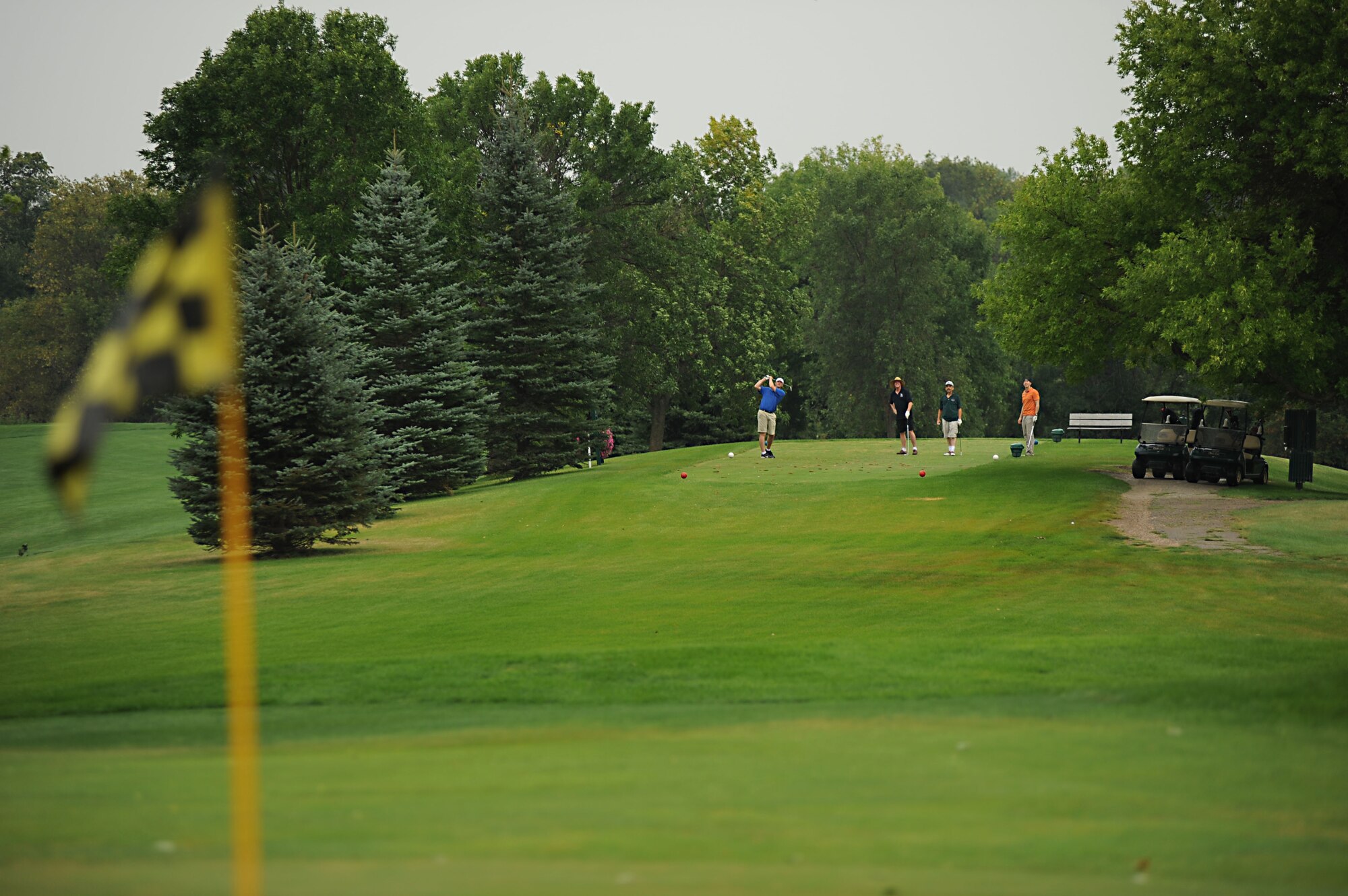 Justin Burchill (left) tees off while, Chief Master Sgt. Ed Keller (middle left), 319th Security Forces Squadron, Jim Fristad (middle right), and Capt. Jason Merrill (right), 319th Air Refueling Wing, watch Aug. 23 during the Military Affairs Committee Golf Tournament at Grand Forks Country Club, N.D. The MAC Golf Tournament is an annual golf scramble consisting of two tournaments, one on Grand Forks AFB and one in the city of Grand Forks. Each four-man team is made up of both base personnel and members of the Grand Forks community. The event has been taking place since the 1980’s and continues to be a unique way for base and community members to interact. (U.S. Air Force photo by Senior Airman Amanda N. Stencil)