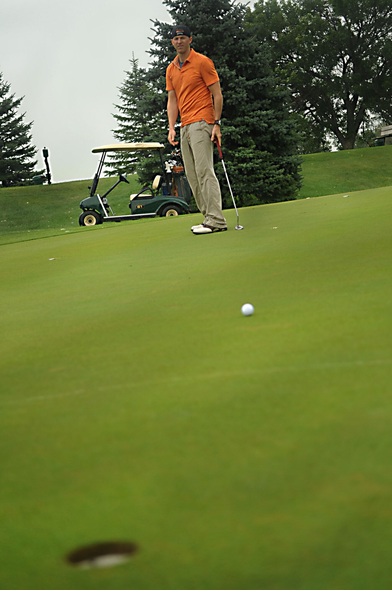 Capt. Jason Merril, 319th Air Refueling Wing, waits for the outcome of his putt Aug. 23 during the Military Affairs Committee Golf Tournament at Grand Forks Country Club, N.D. The MAC Golf Tournament is an annual golf scramble consisting of two tournaments, one on Grand Forks AFB and one in the city of Grand Forks. Each four-man team is made up of both base personnel and members of the Grand Forks community. The event has been taking place since the 1980’s and continues to be a unique way for base and community members to interact. (U.S. Air Force photo by Senior Airman Amanda N. Stencil)