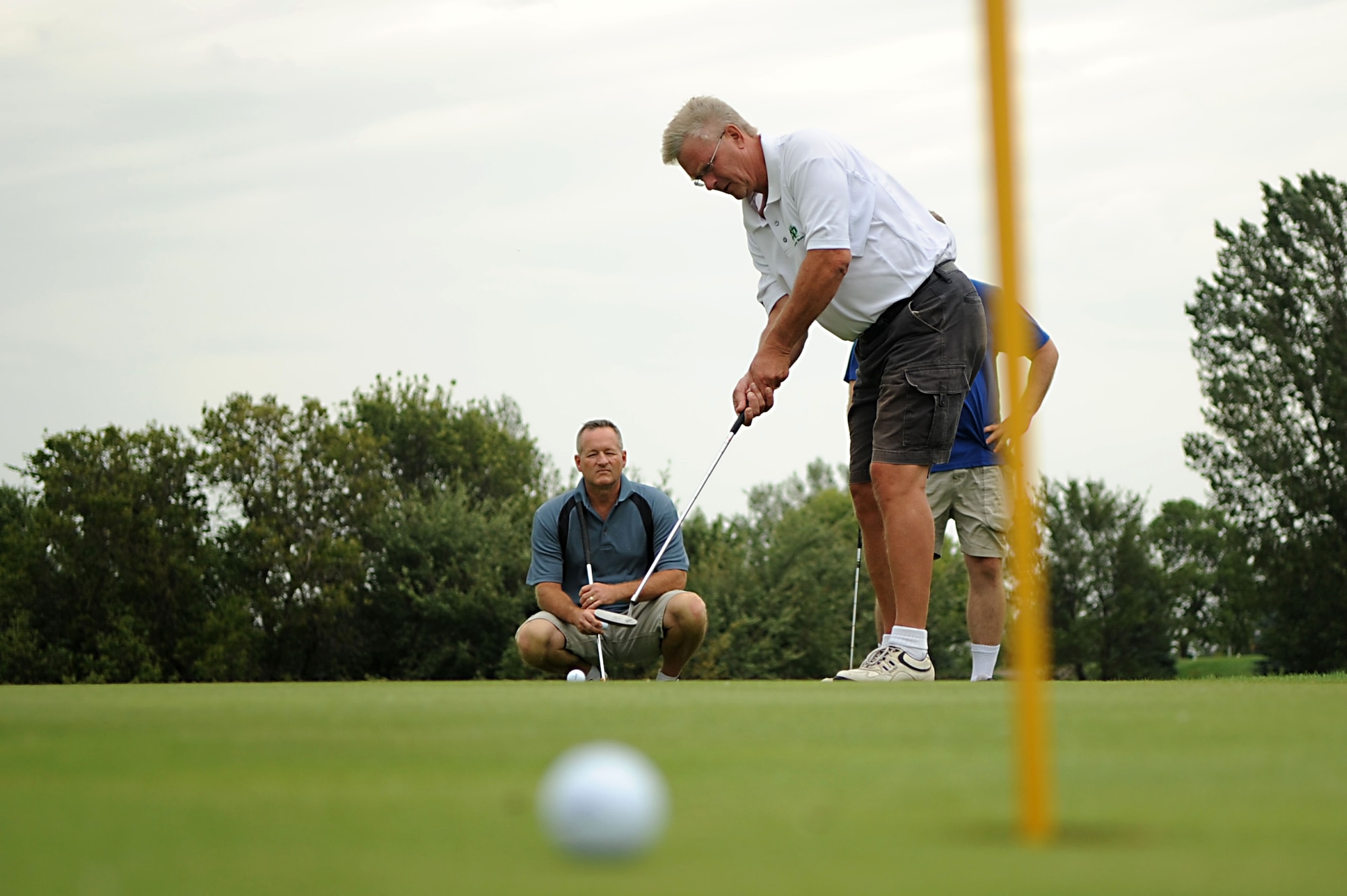 Chief Master Sgt. Chuck Ashworth, 319th Aircraft Maintenance Squadron, watches Jeff Hoplin putt Aug. 23 during the Military Affairs Committee Golf Tournament at Grand Forks Country Club, N.D. The MAC Golf Tournament is an annual golf scramble consisting of two tournaments, one on Grand Forks AFB and one in the city of Grand Forks. Each four-man team is made up of both base personnel and members of the Grand Forks community. The event has been taking place since the 1980’s and continues to be a unique way for base and community members to interact. (U.S. Air Force photo by Senior Airman Amanda N. Stencil)