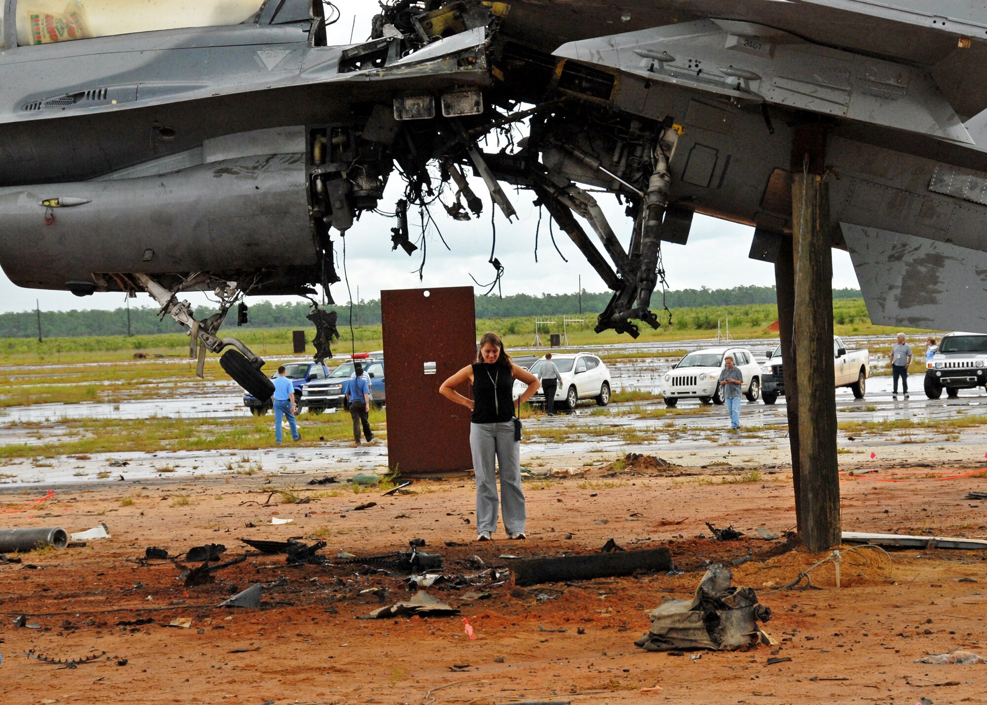 Beth Bartlett, test engineer for the flight termination system test, surveys the damage after the explosion  of an F-16 Fighting Falcon Aug. 19 at the Eglin Air Force Base range.   The explosion was a test of the FTS to be used in the QF-16.  The purpose was to demonstrate that the FTS design will be sufficient to immediately terminate the flight of a QF-16, as well as to determine a range safety debris footprint.  (U.S. Air Force photo/Samuel King Jr.)