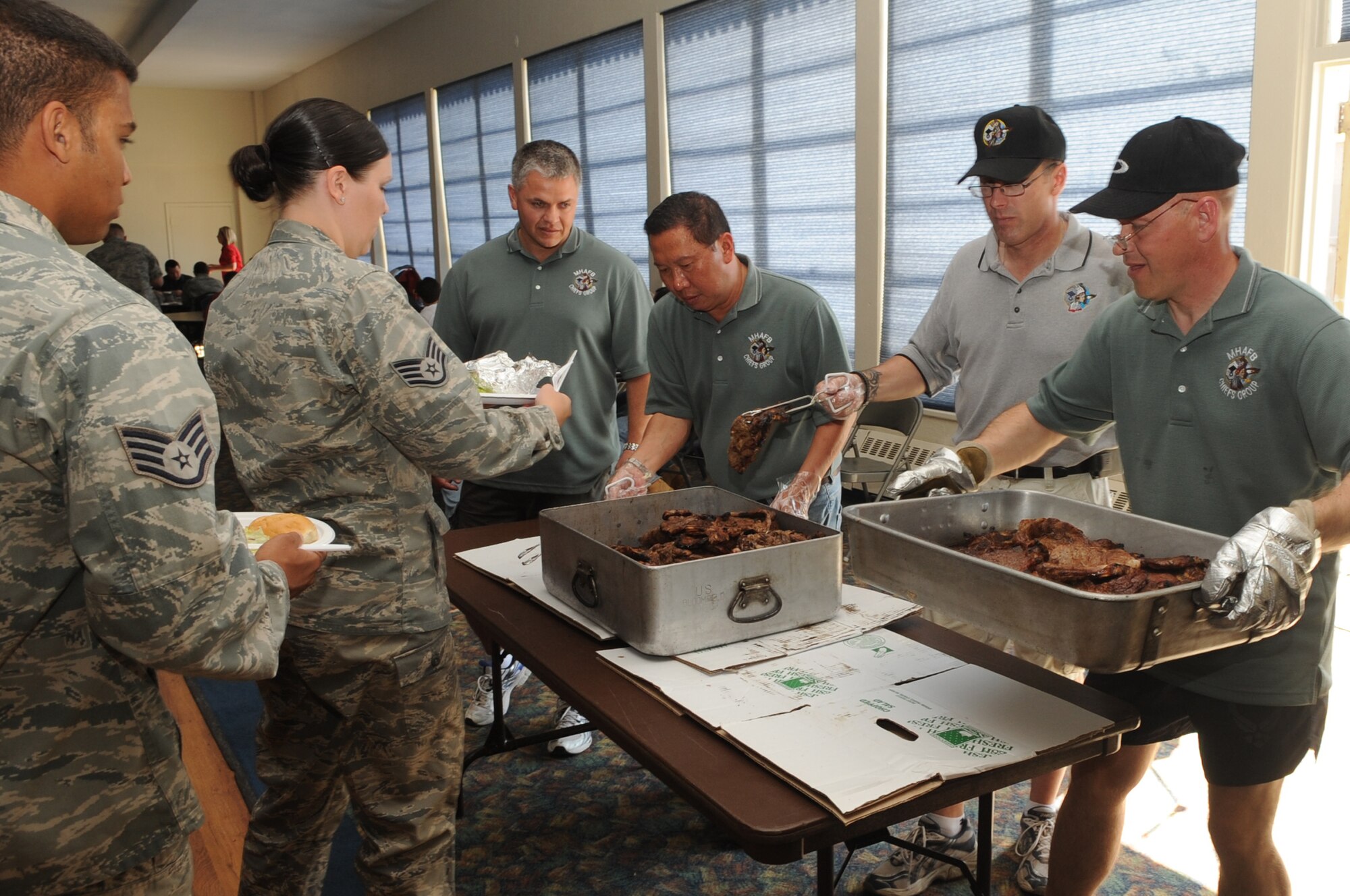 MOUNTAIN HOME AIR FORCE BASE, Idaho -- Volunteers from the Chief’s Group hands out steaks during a Chief’s Steak Burn Aug 18. The Chief’s Steak Burn is held seven times during the summer months and the funds are used to assist different organizations on base. (U.S. Air Force photo by Senior Airman Roy Lynch)
