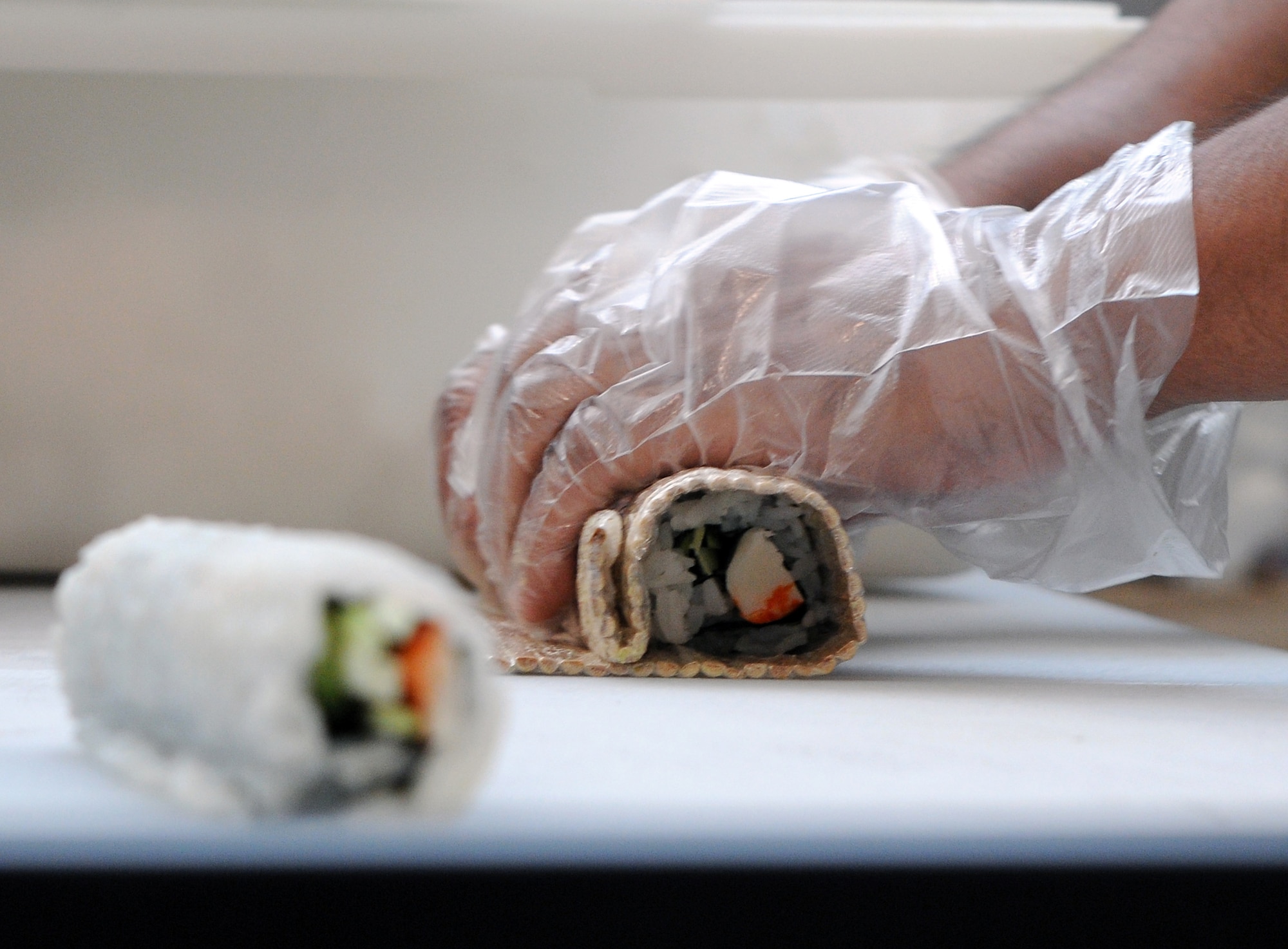Tung Sin, sushi chef, prepares a Kim Bap, more commonly known as a California roll, Aug. 12 at the base commissary sushi bar. The international flavors of sushi have been offered at the commissary for the past three years. (U.S. Air Force photo by Ashley Mangin)