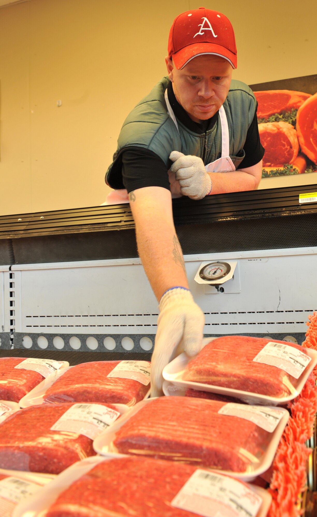 Shawn Siegman, meat cutter, places fresh cut meat in the meat cooler Aug. 12 on base. The commissary staffs meat cutters to process different cuts of beef and pork on the premises. (U.S. Air Force photo by Staff Sgt. Chris Willis)