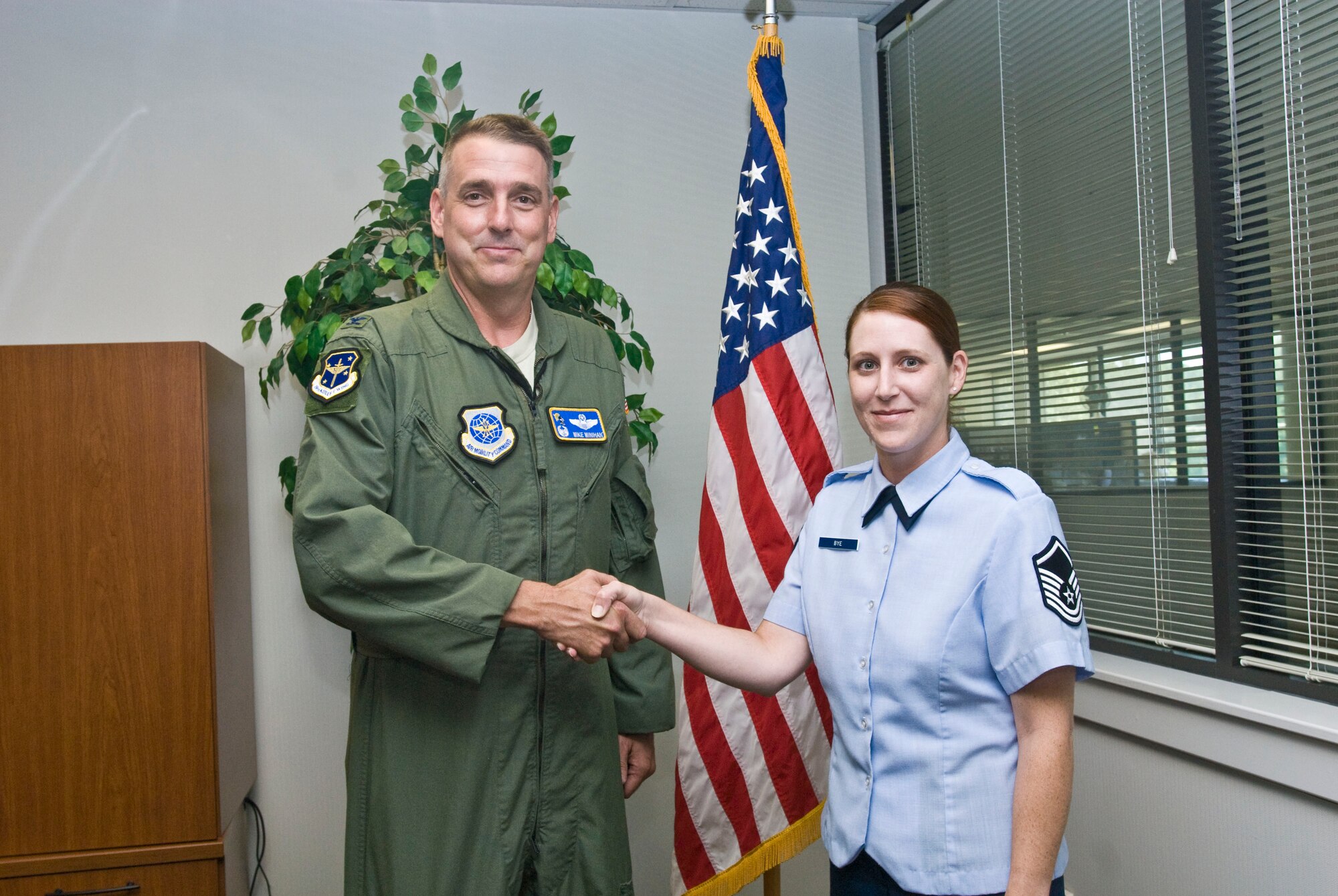Col. Mike Minihan, 19th Airlift Wing commander, presents a coin Aug. 16 here to Master Sgt. Jennifer Bye, 19th Force Support Squadron career development superintendent, for her selection as the Combat Airlifter of the Week. Sergeant Bye acted as personnel deployment function lead during the recent ROCKEX exercise and was selected as an outstanding performer. (U.S. Air Force photo by Staff Sgt. Nestor Cruz)