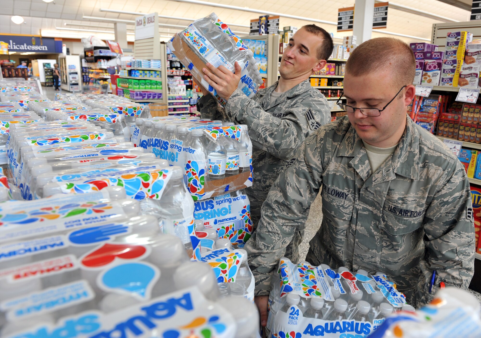 Senior Airman Brandon Oehlke (left) and Senior Airman Christopher Holloway (right), both 19th Component Maintenance Squadron PMEL technicians, pick up cases of water Aug. 12 at the base commissary to restock their shop’s snack bar. They’re two of the commissary’s 38,000 monthly customers. (U.S. Air Force photo by Staff Sgt. Chris Willis)