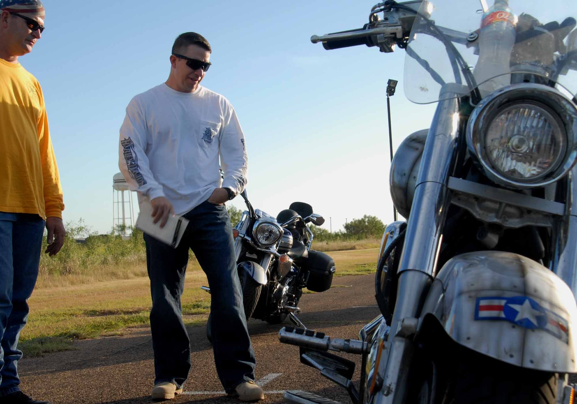 Roy Powell, 17th Logistics Readiness Squadron, and Chief Master Sgt. Brendan Criswell, 17th Training Wing command chief, checks out a motorcycle before an Experienced Riders Course on base Aug. 20. Motorcyclists of all experience levels are encouraged to take the ERC, which allows riders to practice clutch control, pause and go’s, weaving around and over obstacles, in a controlled environment. The course is taught by Southwest Motorcycle Trainer of San Antonio. For more information, contact a unit motorcycle safety representative. (U.S. Air Force photo/ Senior Airman Tong Duong)