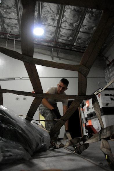 Staff Sgt. Spencer Doll, 18th Aeromedical Evacuation Squadron logistics technician, secures the top cargo net to a pallet during a Local Operational Readiness Exercise (LORE) at Kadena Air Base, Japan, Aug. 24, 2010. The LORE prepared Airmen for real-world contingency operations by simulating a wartime operational environment. (U.S. Air Force photo/Staff Sgt. Darnell T. Cannady)