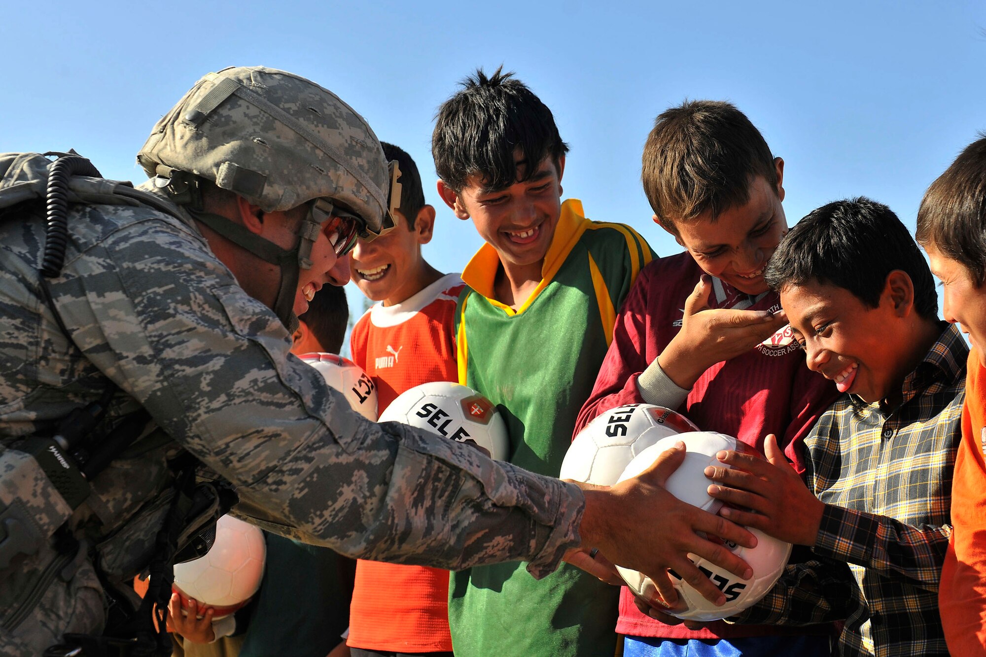 Staff Sgt. Michael Alger, a 455th Expeditionary Security Forces Squadron member, hands out soccer balls to Afghan boys outside of Bagram Airfield, Afghanistan, Aug. 22, 2010. The 455th ESFS compiled soccer equipment donated by the Future Business Leaders of America chapter at Desert Hills High School in Gilbert, Ariz., and distributed as part of a community strengthening program between the coalition forces and the Afghan people. (U.S. Air Force photo/Staff Sgt. Christopher Boitz) 