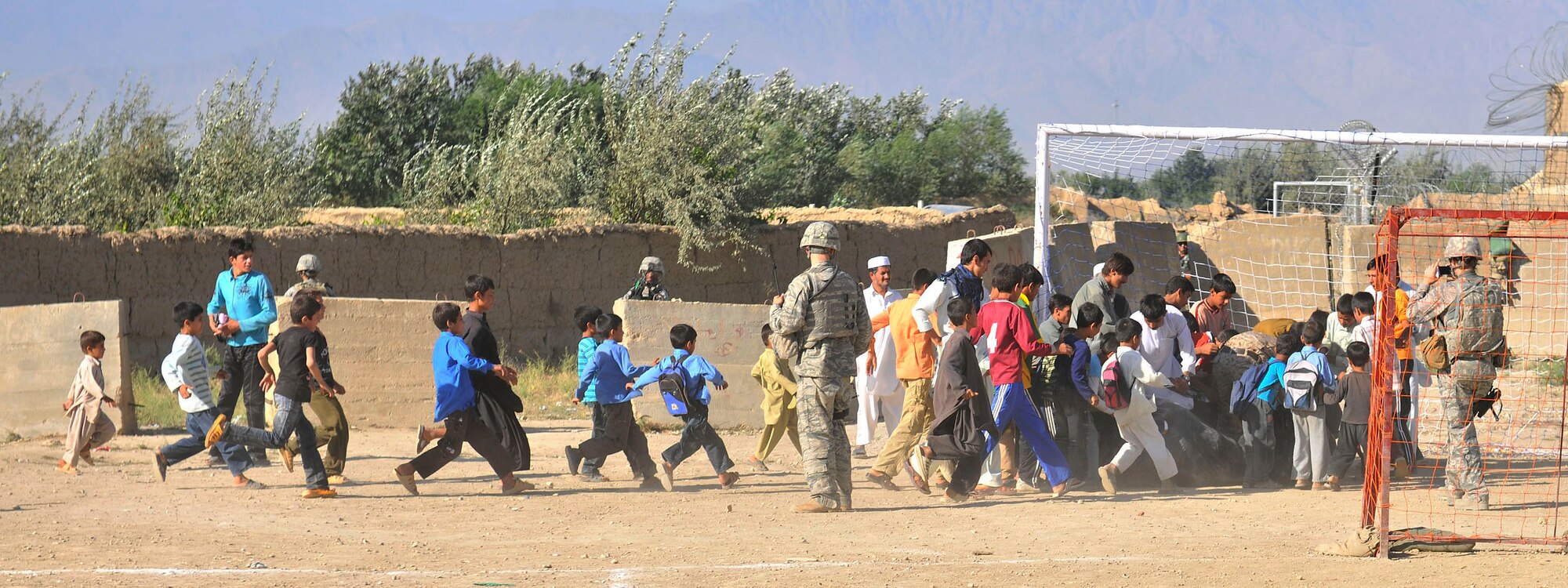 Afghan boys run towards a pile of soccer equipment brought by members of the 455th Expeditionary Security Forces Squadron outside of Bagram Airfield, Afghanistan, Aug. 22, 2010. The 455th ESFS compiled soccer equipment donated by the Future Business Leaders of America chapter at Desert Hills High School in Gilbert, Ariz., and distributed as part of a community strengthening program between the coalition forces and the Afghan people. (U.S. Air Force photo/Staff Sgt. Christopher Boitz)