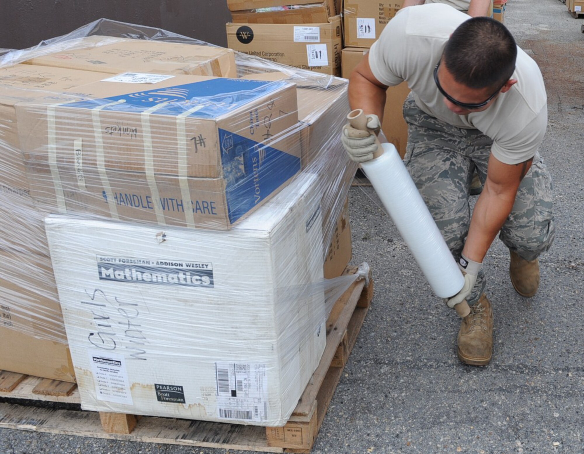 GOLDSBORO, N.C. -- Senor Airman Chana Lawlor secures a pallet with shrink wrap destine for Afghanistan at the MERCI Mission Center Aug. 20, 2010. Airmen from the 4th Logistic Readiness Squadron volunteered their time to help staff at the center package prepare donated food and clothes for shipment. Airman Lawlor, 4th Logistic Readiness Squadron, hails from Brattleboro, Vt. (U.S. Air Force photo/Senior Airman Gino Reyes)