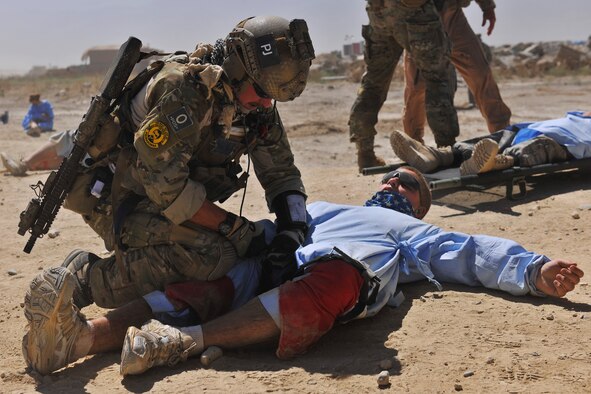 A pararescueman applies a tourniquet to a simulated injured person during an exercise at Bagram Airfield, Afghanistan, Aug. 21. 2010. The exercise tested the rescue squadron?s ability to provide medical aid to U.S. and Coalition forces. (U.S. Air Force photo/Staff Sgt. Christopher Boitz)