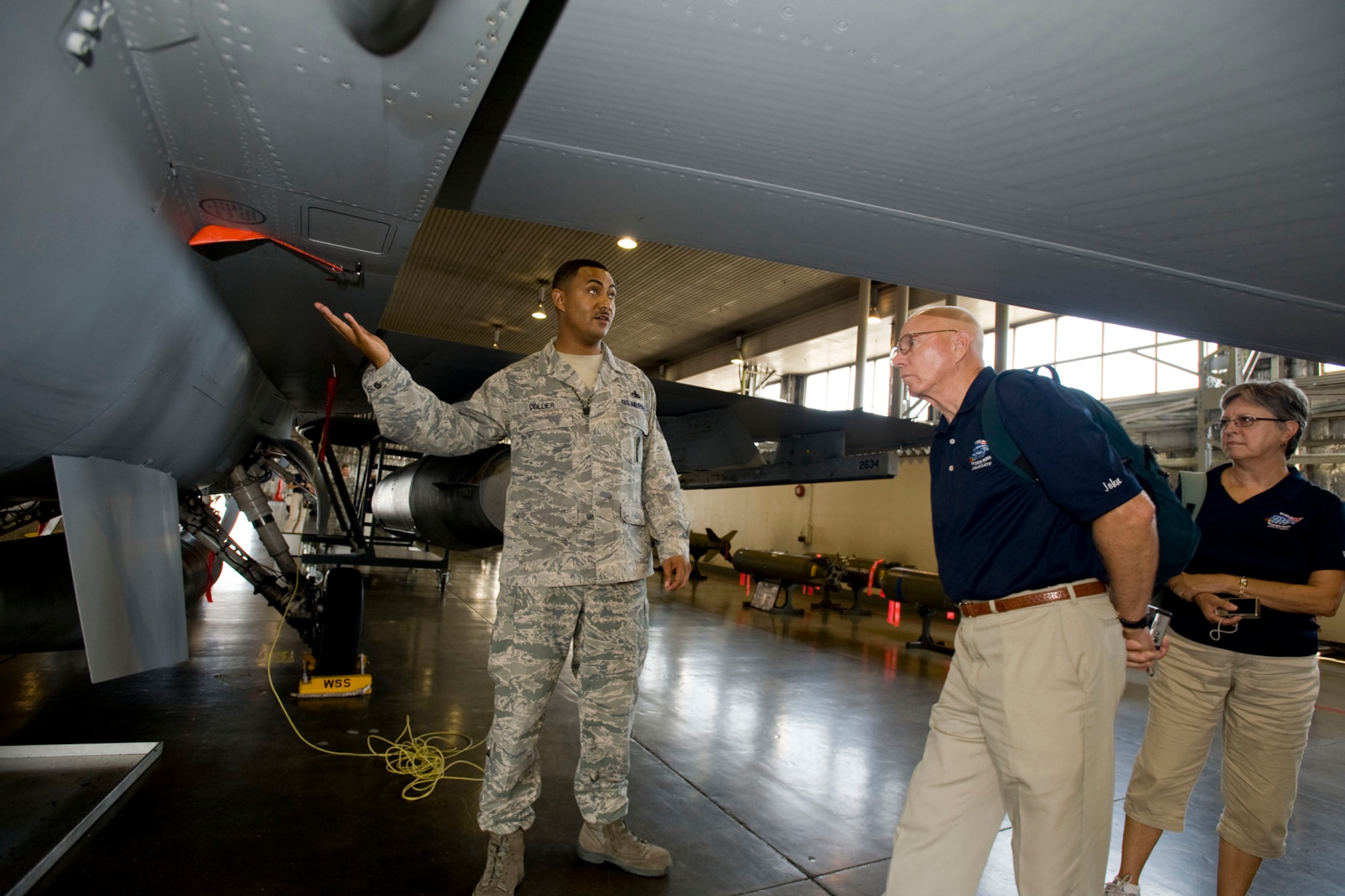 MISAWA AIR BASE, Japan -- Master Sgt. Andre Collier, loading standardization crew chief, explains capabilities of the F-16 Fighting Falcon to U.S. Navy Lt. Cmdr. (Ret) John Sweeney and his wife, Pauline, Aug. 20 at Hangar 911. Mr. and Mrs. Sweeney are part of the Wenatchee, Washington, delegation and visited Misawa to experience Japanese culture and take part in the annual Misawa Summer Festival. (U.S. Air Force photo/Senior Airman Jamal D. Sutter)