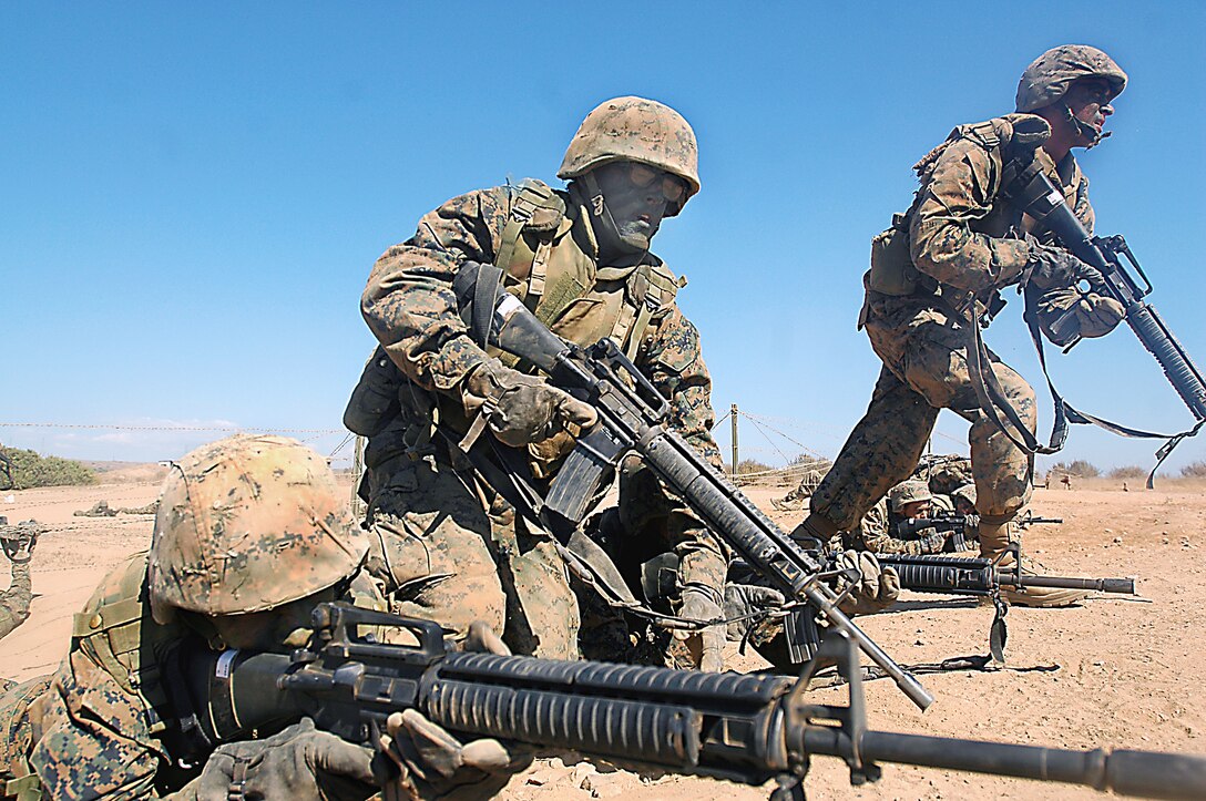 Company K recruits buddy rush a simulated enemy postition during Copland's Fire Team Assault Course at Edson Range, Marine Corps Base Camp Pendleton, Calif., Aug. 24. The course is designed to test recruits' communication and teamwork abilities while also improving them.