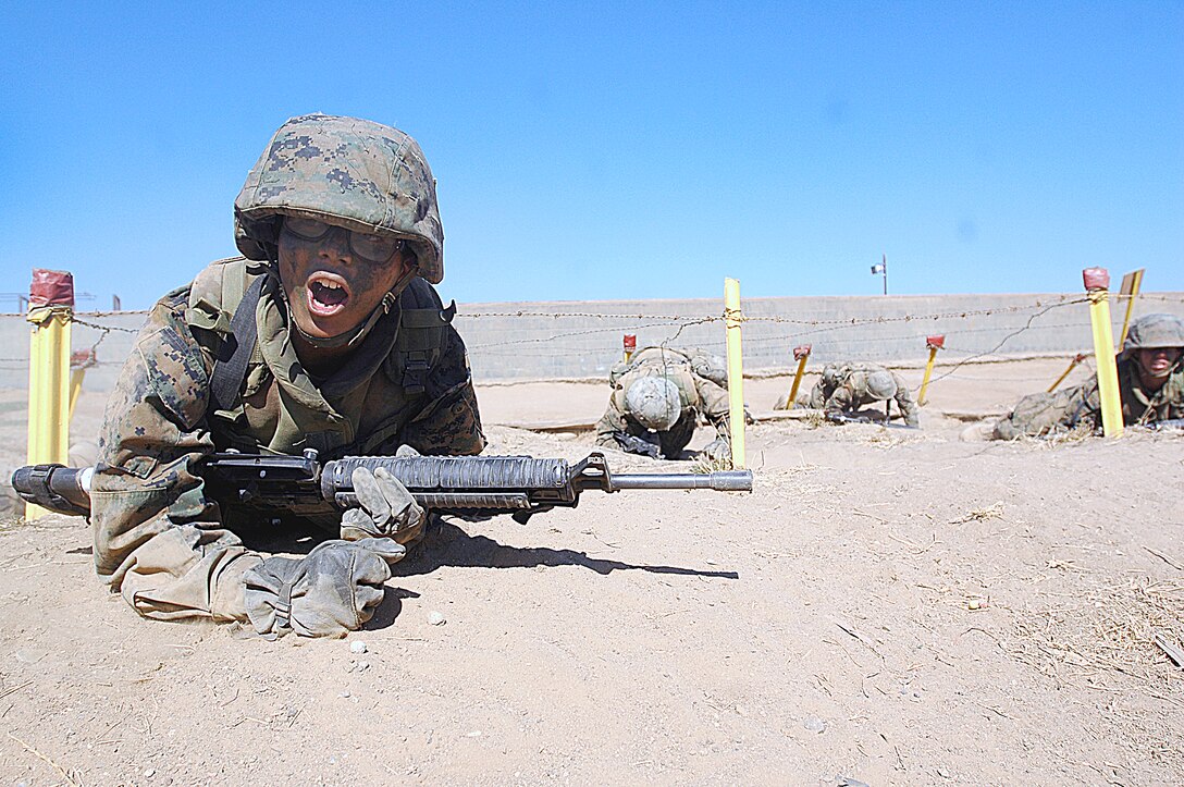Recruit Robert Streety, Platoon 3233, yells for his fire team as he finishes low-crawling the second high barbed-wire obstacle of Copland’s Fire Team Assault Course during the Crucible at Edson Range, Marine Corps Base Camp Pendleton, Calif., Aug. 24. The course represents recruits counterattacking an enemy position after their Armored Personnel Carriers are ambushed and is supposed to help recruits communicate more effectively and increase their mental toughness.