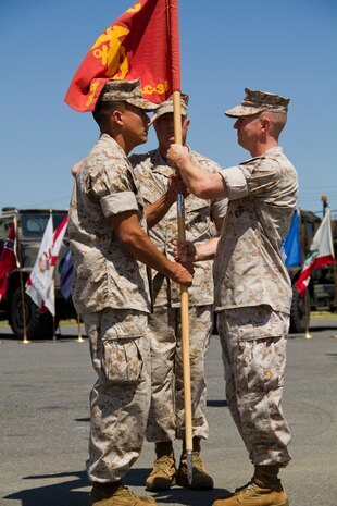 Maj. Dustin R. Thorn, right, passes the guidon signifying the passing of command to Maj. Andres Caceres-Solari during the Combat Logistics Company 36 change-of-command ceremony here Aug. 25. Change-of-command ceremonies are a time honored tradition that formally state to the members of the command the continuity of the authority of command.