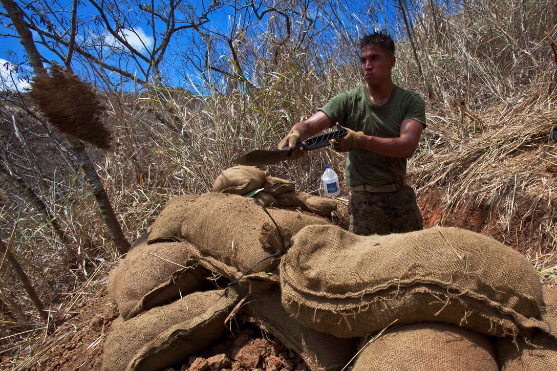 Lance Cpl. Rusty McGrady, a student with the Infantry Squad Leader Course, School of Infantry West — Detachment Hawaii, prepares his fighting position during the defensive tactics and techniques portion of the course at Marine Corps Training Area Bellows Aug. 24. Over the course’s 45 training days, students also learn advanced patrolling, military operations in urban terrain, demolitions, land navigation, combat hunter, fire plan sketches, and conduct unit training management.