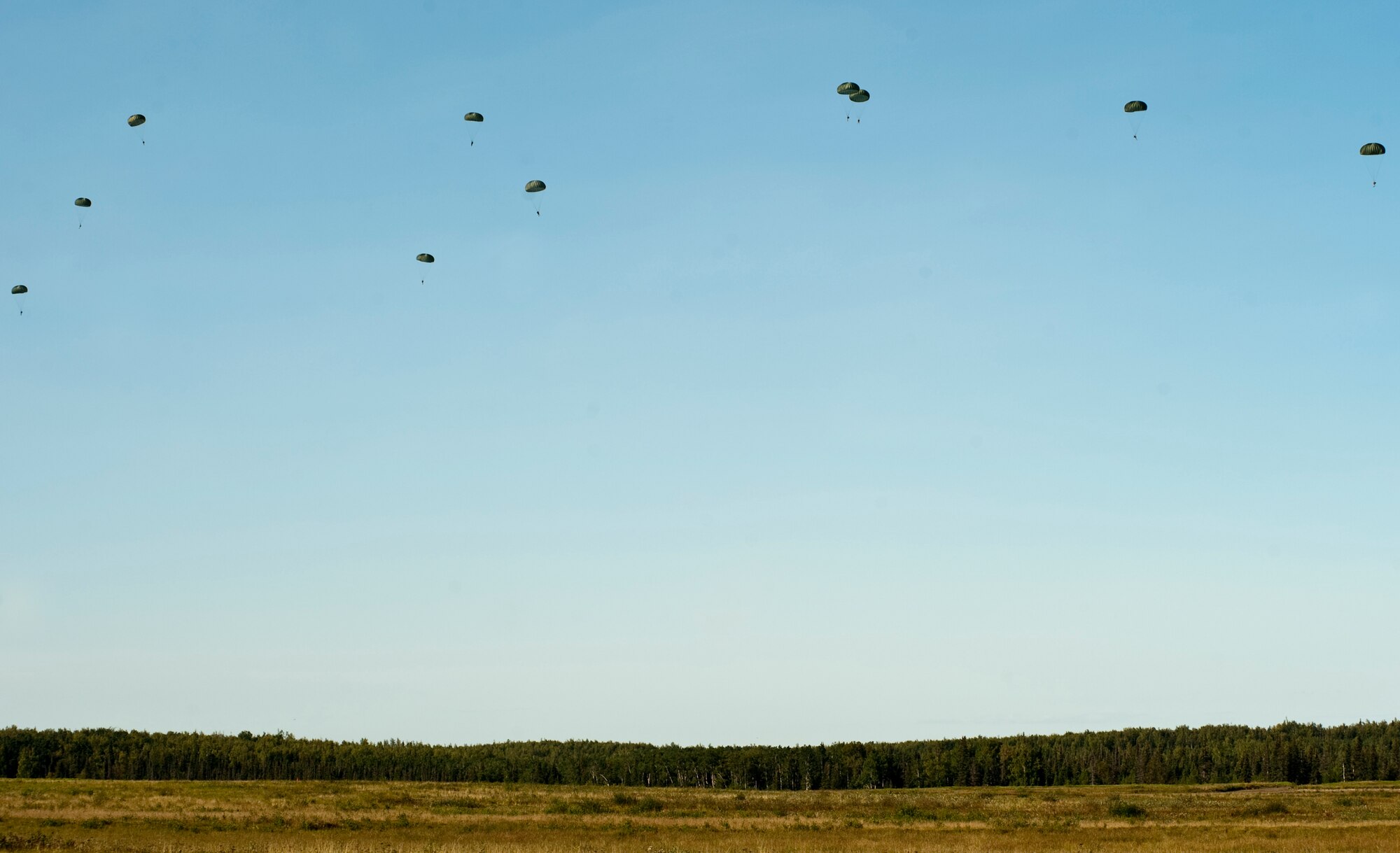 JOINT BASE ELMENDORF-RICHARDSON, Alaska -- Soldiers make their way to the ground after jumping from the back of a C-130 Hercules Aug. 25. Approximately 50 members of the 425th Brigade Special Troops Battalion participated in a three-week path finder course at Joint Base Elmendorf-Richardson. Instruction included sling load operations, helicopter landing and pickup zone operations along with drop zone operations. (Photo by Airman 1st Class Christopher Gross)