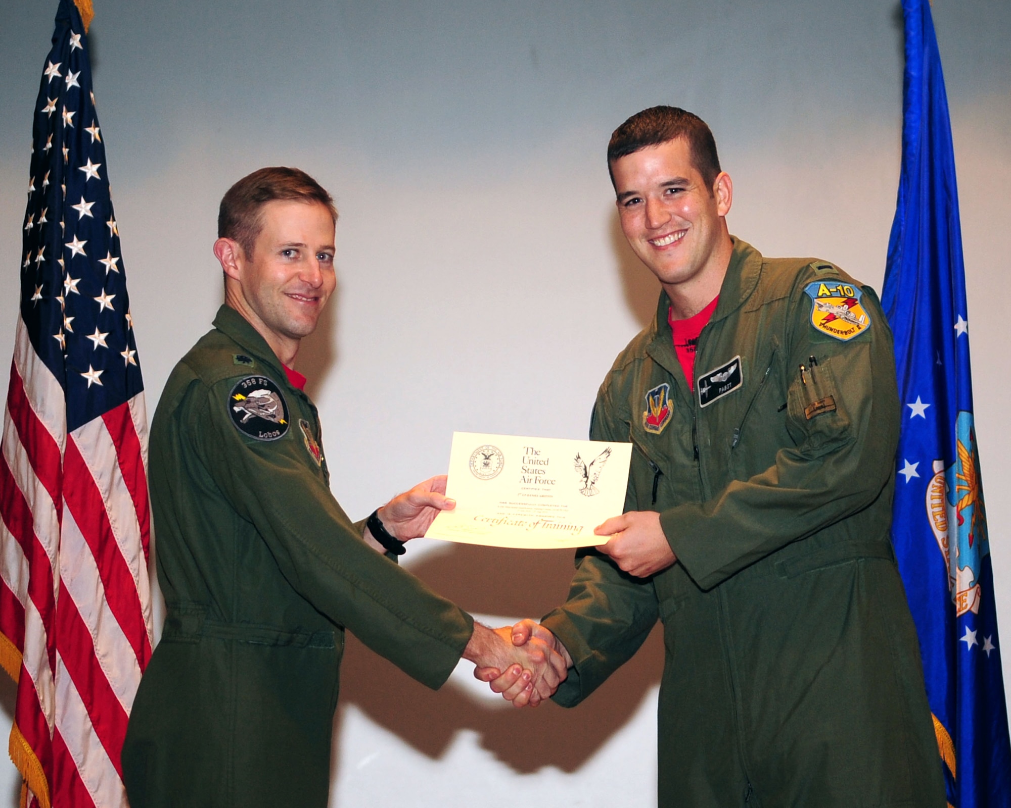 Lt. Col. Scott Campbell, 358th Fighter Squadron commander, presents a graduation certificate to 1st Lt. Dan Griffin, certifying his completion of the A-10C Pilot Initial Qualification Course Class 10-BBD at the base theater here Aug. 13, 2010. Lieutenant Griffin was one of 12 students to most recently complete the 27-week training course, becoming the Air Force’s newest A-10C pilots. (U.S. Air Force photo/Airman 1st Class Jerilyn Quintanilla)