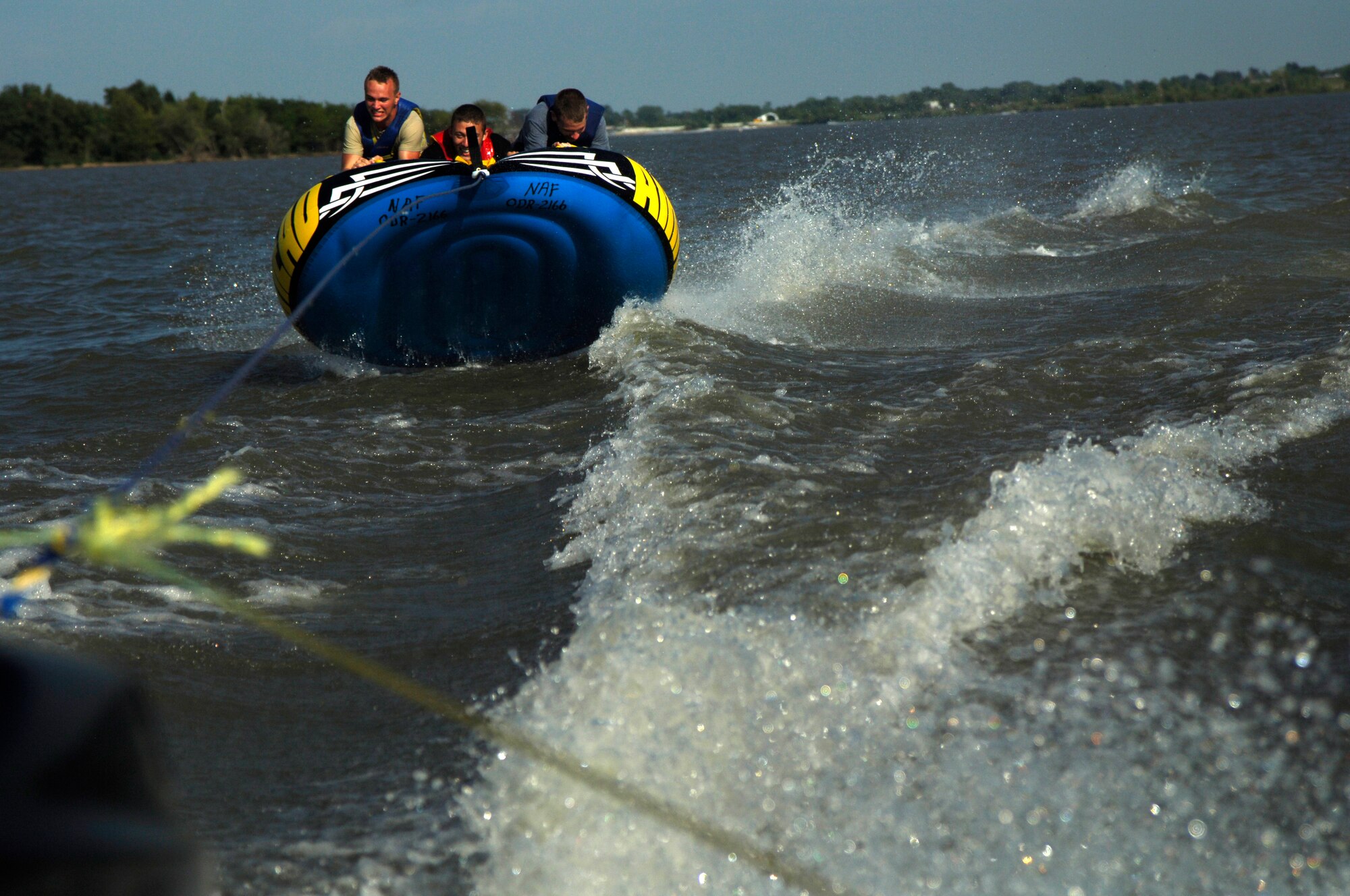 (From left to right) Airman 1st Class Andrew Gordon, 22nd Logistic Readiness Squadron fuel specialist apprentice, Airman 1st Class William Smith, 22nd Aircraft Maintenance Squadron communication and navigation apprentice, Airman 1st Class Thomas Patterson, 22nd Communications Squadron client systems technician, hold on a tube at El Dorado Lake, Kan. Aug. 21, 2010. The Airmen were on a retreat for young Airmen hosted by the base chapel. The chapel hosts a minimum of four similar events annually targeting different demographics at McConnell. (U.S. Air Force photo/Airman 1st Class Armando A. Schwier-Morales)