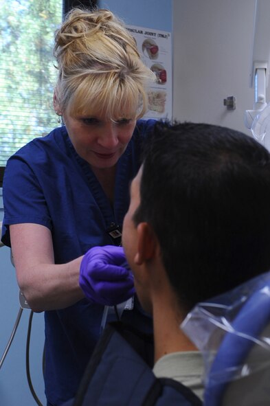ELLSWORTH AIR FORCE BASE S.D. – Jacqueline Milnes, 28th Medical Operations Squadron dental contract assistant, prepares digital dental X-rays of Staff Sgt. Chris Coniglio, 28th Force Support Squadron food service team lead, Aug. 24.  Ms. Milnes X-rays Sergeant Coniglio’s teeth as part of his annual dental exam. (U.S. Air Force photo/Senior Airman Kasey Close)