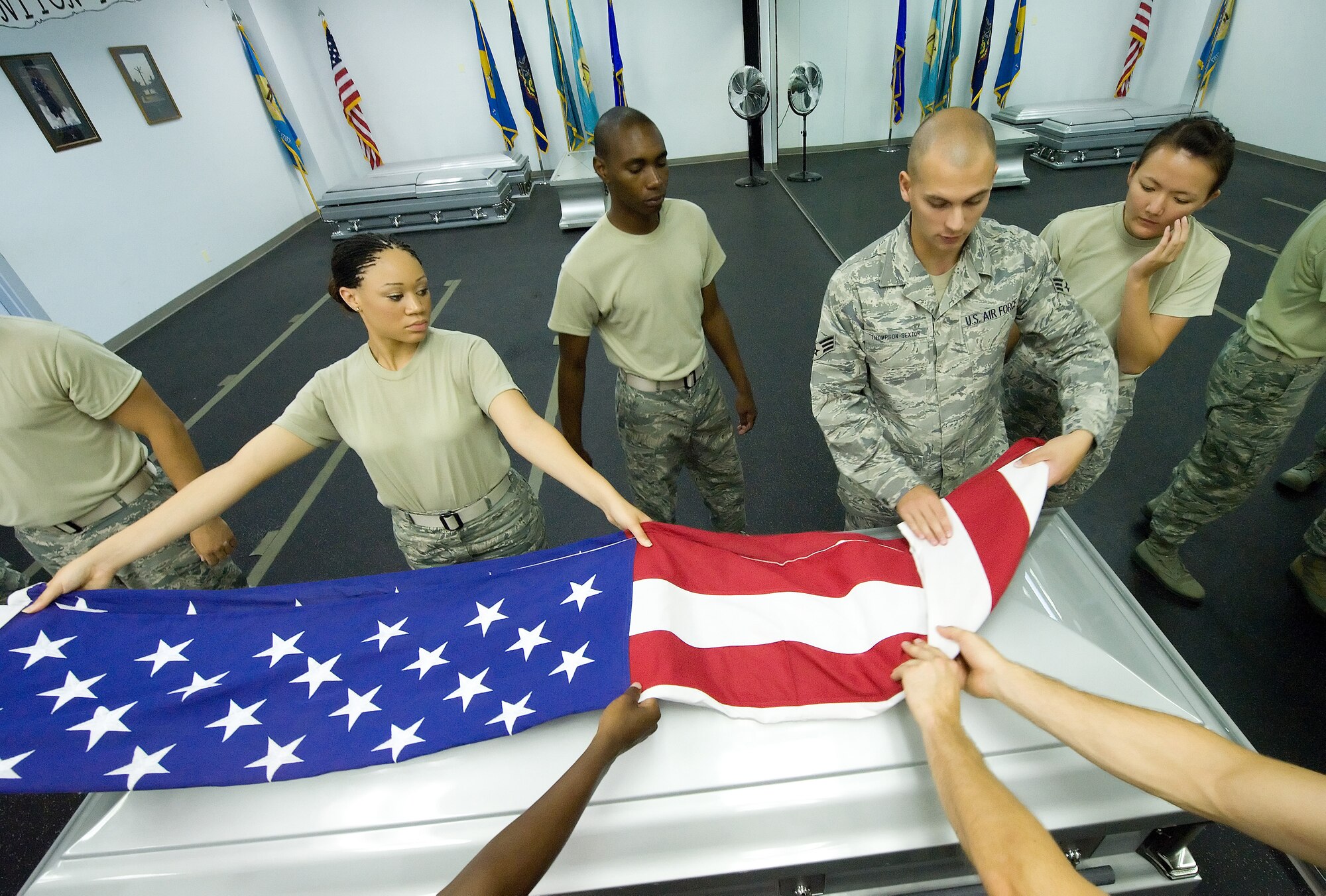 Senior Airman Joseph Thompson-Sexton, U.S. Air Force Honor Guard, demonstrates to Team Dover members how to properly fold a flag during training at the Base Honor Guard on Dover Air Force Base, Del., Aug. 13, 2010. Instructors from the U.S. Air Force Honor Guard visited to train Team Dover members on various Honor Guard duties. (U.S. Air Force photo by Jason Minto/Released)