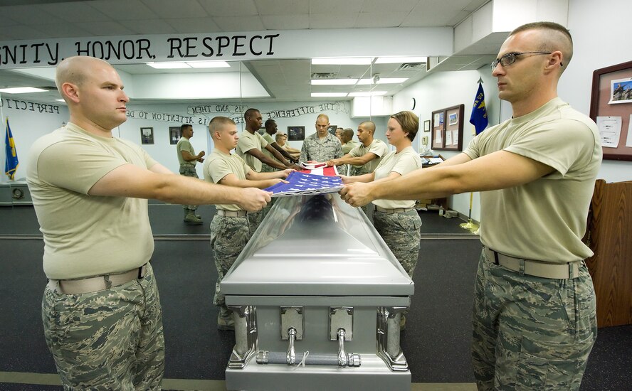 Team Dover Honor Guard members fold a flag over a casket during training at the Base Honor Guard on Dover Air Force Base, Del., Aug. 13, 2010. Instructors from the U.S. Air Force Honor Guard visited to train Team Dover members on Honor Guard duties. (U.S. Air Force photo by Jason Minto/Released)