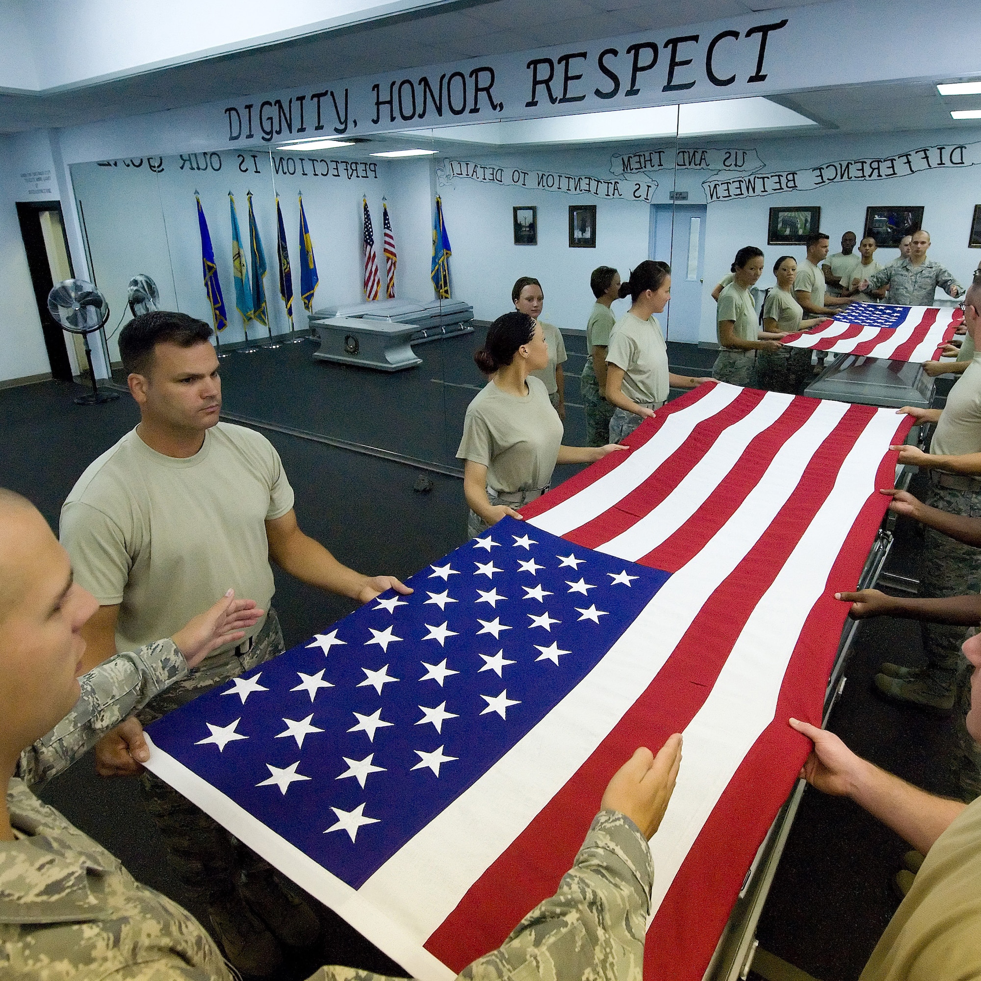 Members of the Team Dover Honor Guard learn how to properly fold a flag for ceremonies during training at the Base Honor Guard on Dover Air Force Base, Del., Aug. 2010. Instructors from the U.S. Air Force Honor Guard visited to train Team Dover members on Honor Guard duties. (U.S. Air Force photo by Jason Minto/Released)