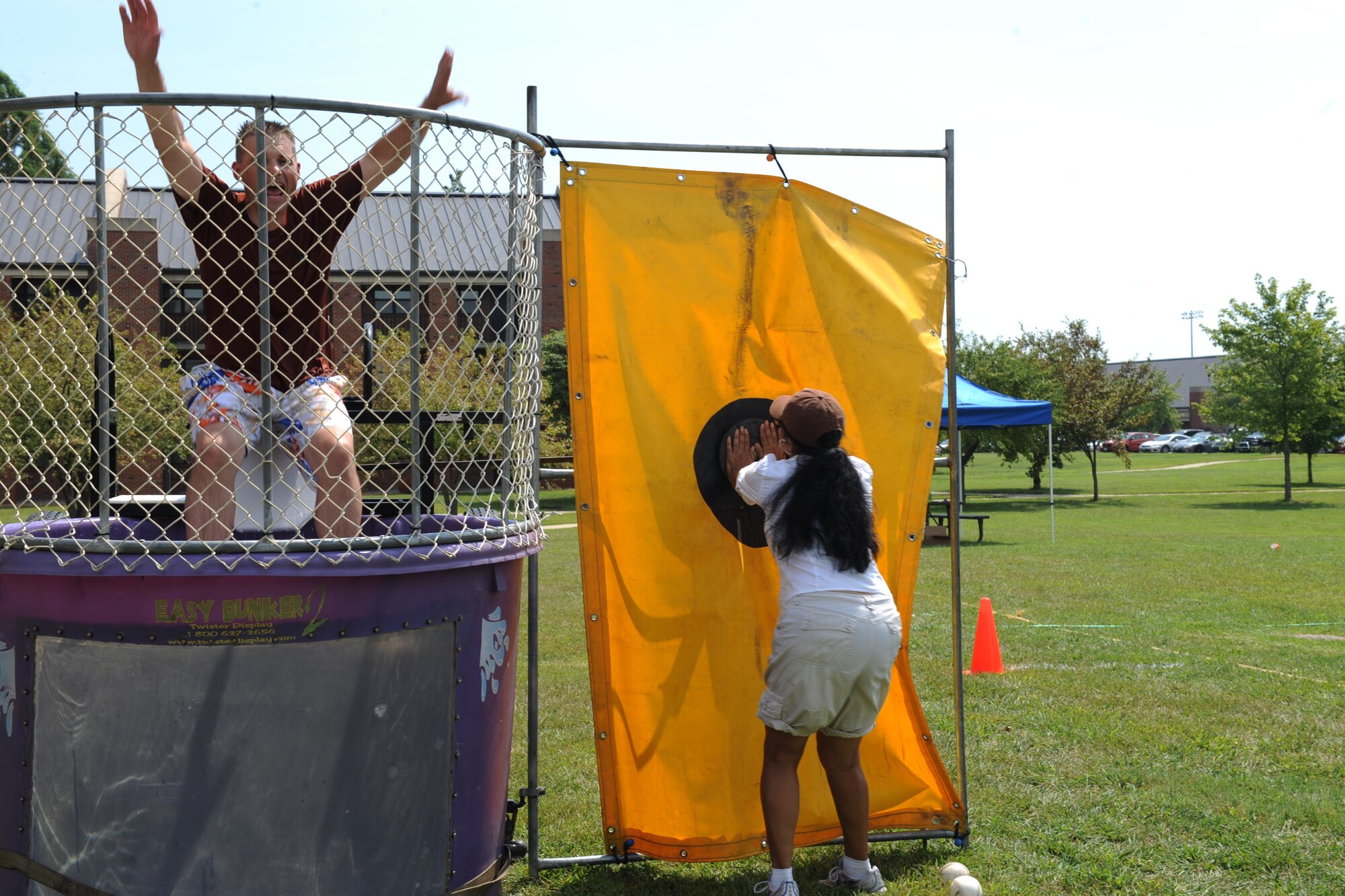 SCOTT AIR FORCE BASE, Ill. -- Chaplin (Capt.) Ann Luna, 375th Air mobility Wing Chapel, pushes the button to dunk Col. Hornitschek in the dunk tank. The first member who was able to successfully dunk Col. Hornitschek received a free day pass. (U.S. Air Force photo/Senior Airman Tristin English)