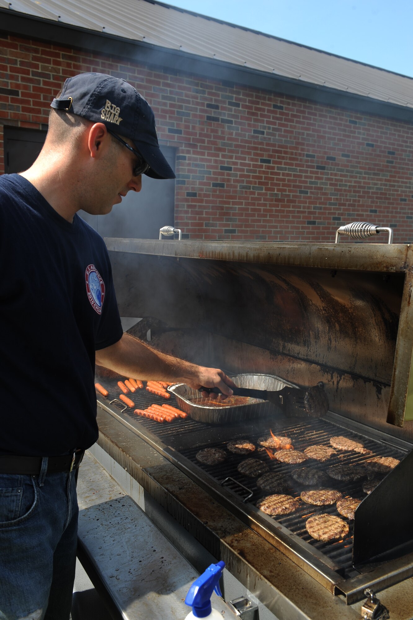 SCOTT AIR FORCE BASE, Ill. -- Chaplain (Capt.) Michael Carey, 375th Air Mobility WIng, grills hamburgers and hot dogs for the Airmen at the Dorm Olympics Aug. 20. Free food and music were provided to the Airmen while they competed against other Airmen in the dorms. (U.S. Air Force photo/Senior Airman Tristin English)