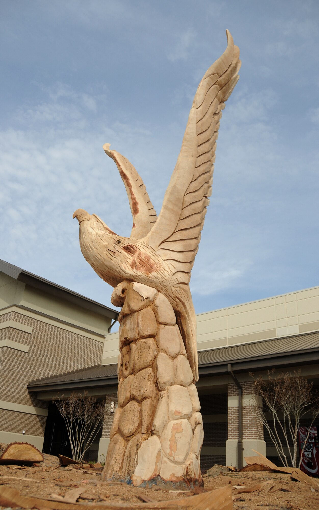 Artist Marlin Miller transformed a 7½ ton remnant of wood from a tree felled by Katrina into a soaring eagle that symbolizes Keesler’s resilience, resurgence and hope.  The carving, part of Mr. Miller’s coastwide Katrina sculpture project, is in front of Keesler’s new shopping complex.   (U.S. Air Force photo by Kemberly Groue)
