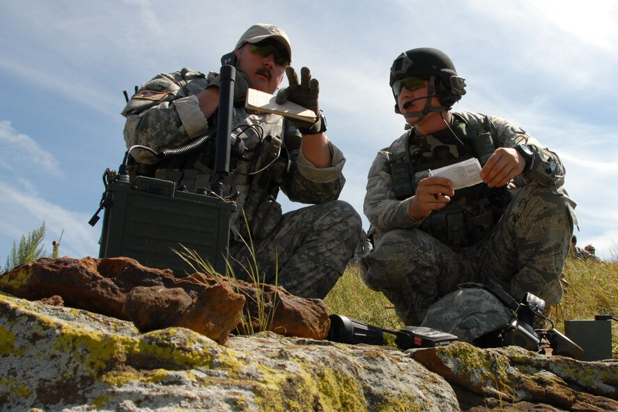 A1C Andrew Jundt listens as Lt. Col. Gary Nash directs an air strike on a nearby building during a close air support exercise Aug. 19 at Smoky Hill. 