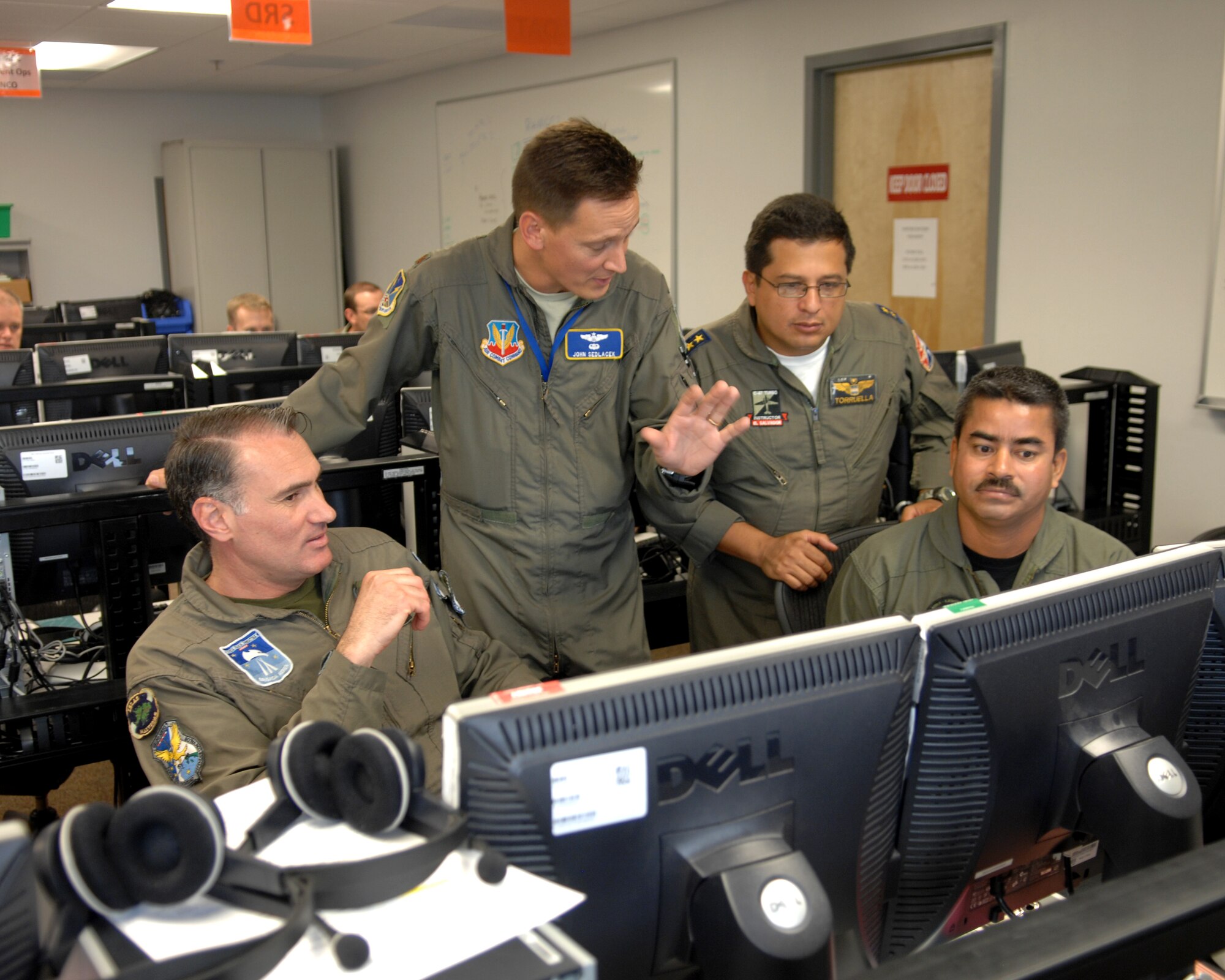 Maj. John Sedlacek (second from left), deputy chief of the 612th Combined Air Operations Center Air Mobility Division, explains an exercise scenario to Maj. Hugo Fiocca (left) of the Argentina air force, Lt. Col. Raymundo Torruella, from the El Salvador air force, and Lt. Col. Eugene Alfaro of the Nicaraguan army. Seventeen partner nations came together at D-M for Exercise Panamax, an annual exercise focused on the defense of the Panama Canal. This year, Air Forces Southern also integrated a simulated humanitarian relief operation into the Panamax scenario, building on lessons learned during recent earthquake and hurricane disaster response efforts in Latin America. (U.S. Air Force photo/Staff Sgt. Jake Richmond)
