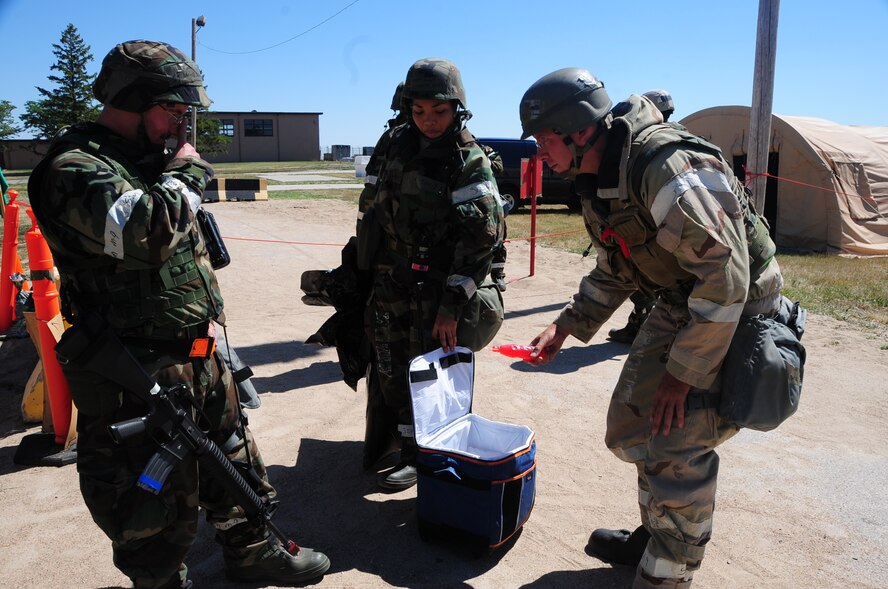 ELLSWORTH AIR FORCE BASE, S.D. -- (Right) Staff Sgt. Kenneth Dale, 28th Civil Engineer Squadron heating, ventilation and air-conditioning craftsman, grabs drinks for himself and (left) Staff Sgt. Jacob Schuhardt, 28 CES water and fuels maintenance craftsman, from (center) Staff Sgt. Shanita Ware, 28th Bomb Wing Staff chaplain assistant, during a phase II operational readiness exercise, Aug. 24.  The chapel Airmen went around providing drinks and snacks to the exercise players. (U.S. Air Force photo/Airman 1st Class Anthony Sanchelli)