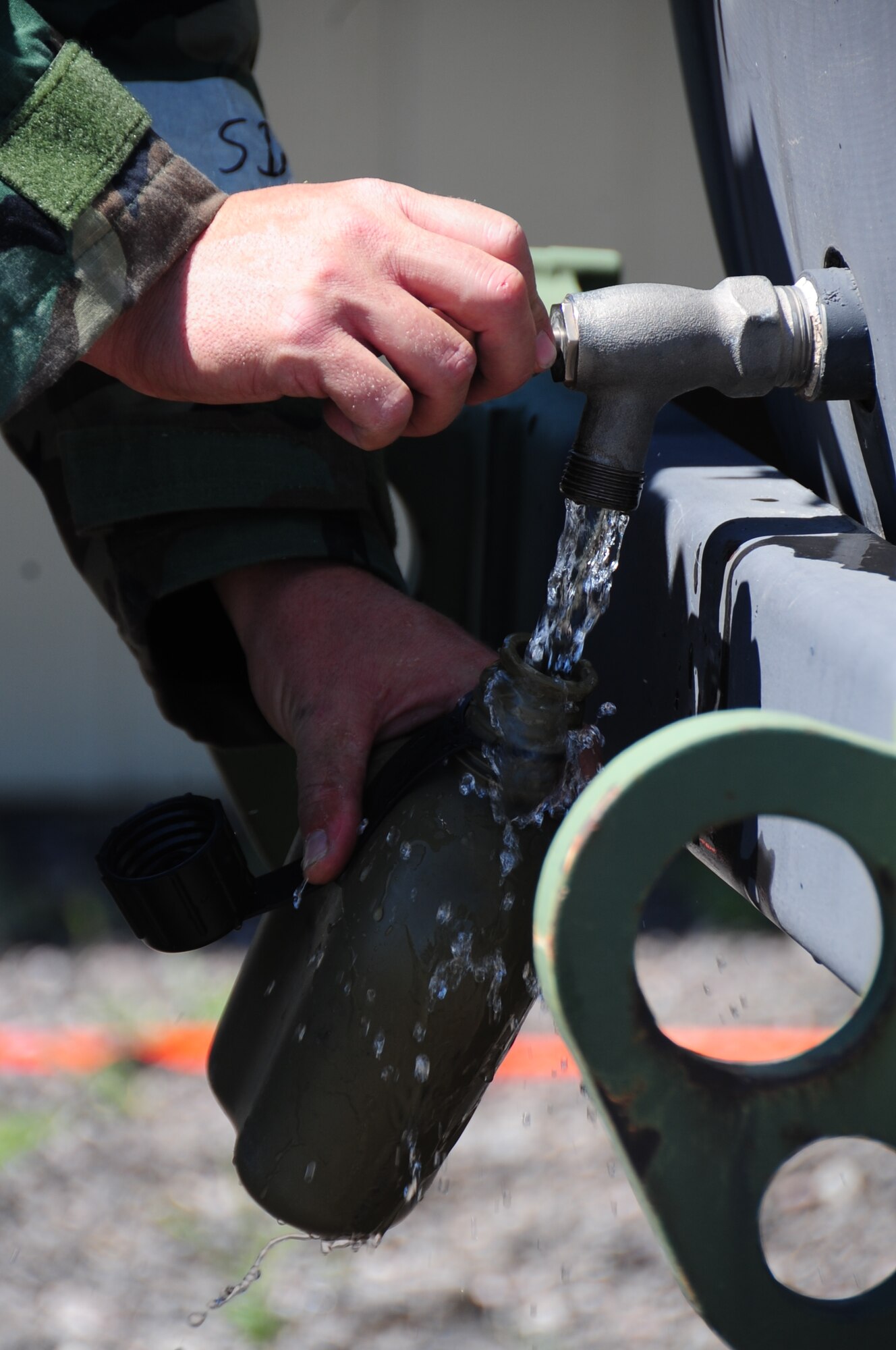 ELLSWORTH AIR FORCE BASE, S.D. -- Airman 1st Class Eric Judd, 28th Medical Operations Squadron medical technician, fills up his canteen during a phase II operational readiness exercise, Aug. 24.  Staying hydrated is essential to avoiding heat stoke and dehydration. (U.S. Air Force photo/Airman 1st Class Anthony Sanchelli)