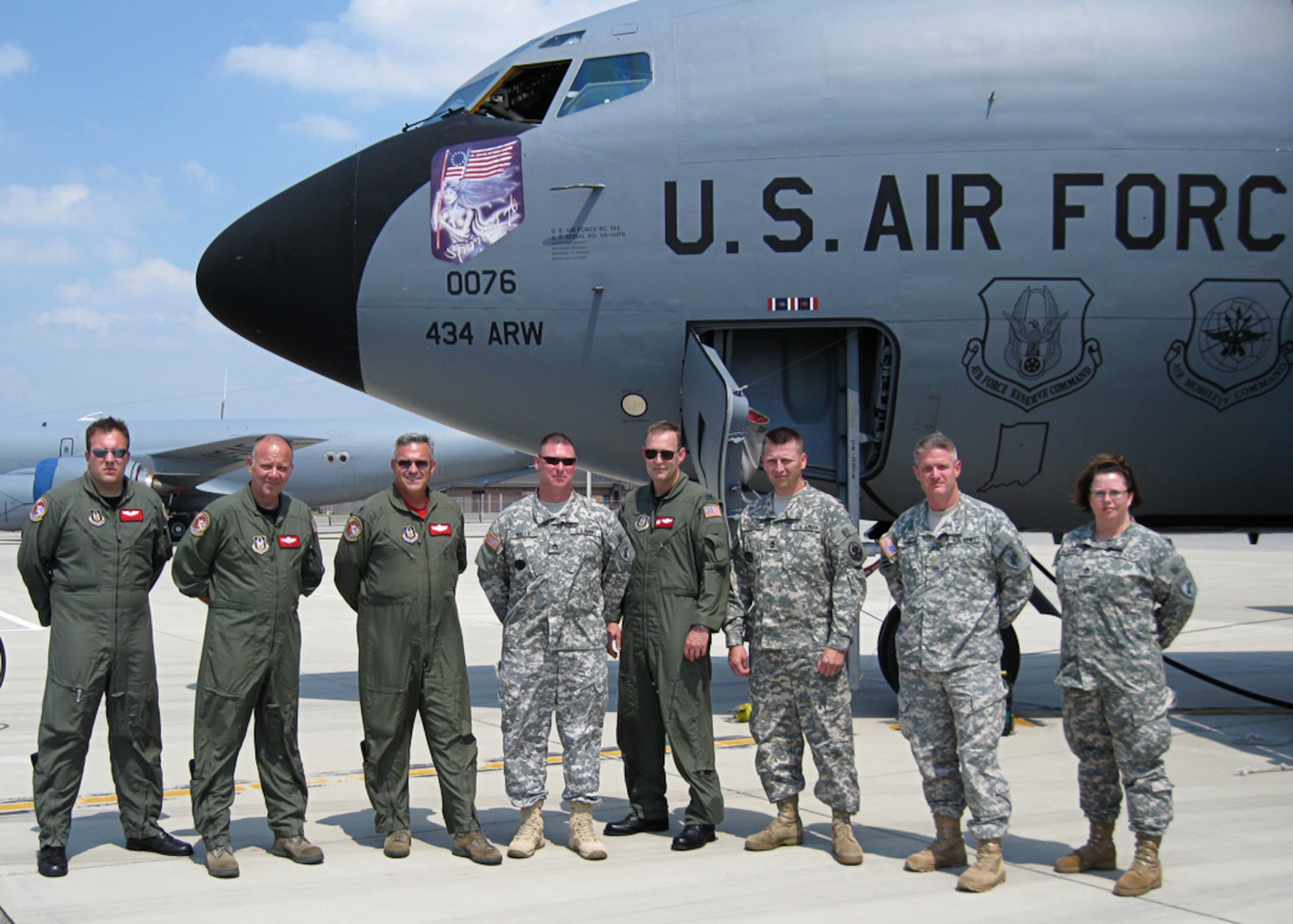 GRISSOM AIR RESERVE BASE, Ind. -- Reserve Airmen and Soldiers pose for a photo outside of a KC-135R Stratotanker after getting back from an aerial refueling mission Aug. 20. The Airmen, from the 74th Air Refueling Squadron, took Soldiers from the 316th Psychological Operations Company on an orientation flight, where one Soldier reenlisted. From left to right are Staff Sgt. Brandon Toth, Master Sgt. Jerry Schumacher, Lt. Col. John Pannel, Staff Sgt. John Walls, Col. William Mason, Sgt. 1st Class Gary Jensen, Maj. Scott Thomson and Staff Sgt. Tobe Hutchins. Colonel Mason is the 434th Operations Group commander. (U.S. Army photo/ Staff Sgt. Tobe Hutchins)    