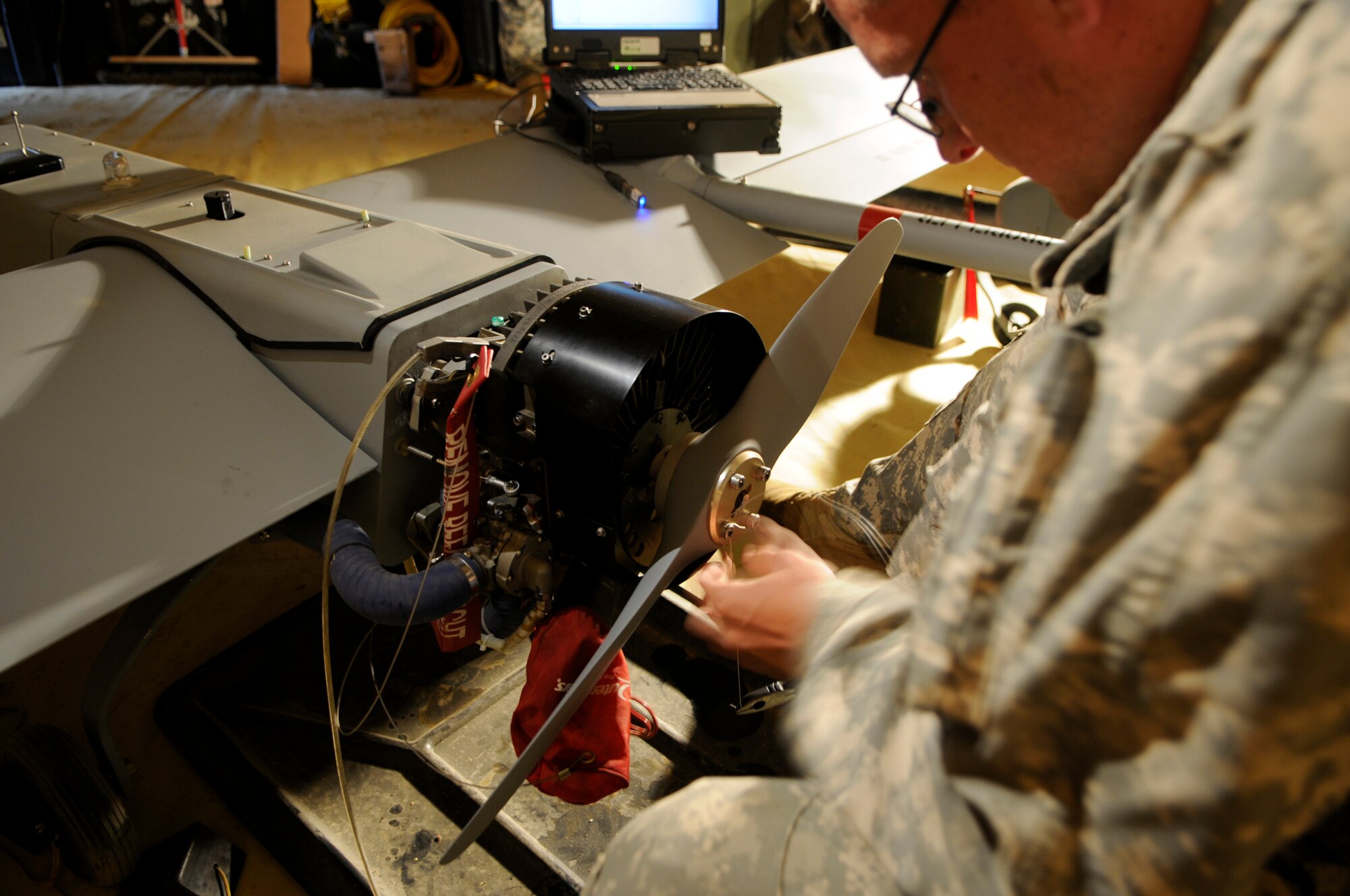 Spc. Timothy Baker performs routine inspections and maintenance of the RQ-7B Shadow Aug. 19, 2010, Eielson Air Force Base, Alaska.  When not flying the aircrafts, Soldiers house the unmanned aircraft system in small hangars where operators check all flying equipment to ensure mission readiness. Specialist Baker is a Delta Troop 5th Squadron 1st Cavalry Regiment 1/25th Stryker Brigade Combat Team unmanned aircraft system operator, at Fort Wainwright. (U.S. Air Force photo/Airman 1st Class Yash Rojas)
