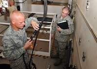 MINOT AIR FORCE BASE, N.D. -- Senior Airman James Hardy, 91st Missile Maintenance Squadron missile maintenance team technician, makes equipment checks on his team’s vehicle prior to departure while Staff Sgt. Jason Keen, 91st Maintenance Group quality assurance evaluator, watches here Aug. 18. Vehicle inspections like these are administered by a two-man team to ensure the safety of both Airmen and Air Force assets while in movement through the missile field.  (U.S. Air Force photo by Senior Airman Michael J. Veloz)