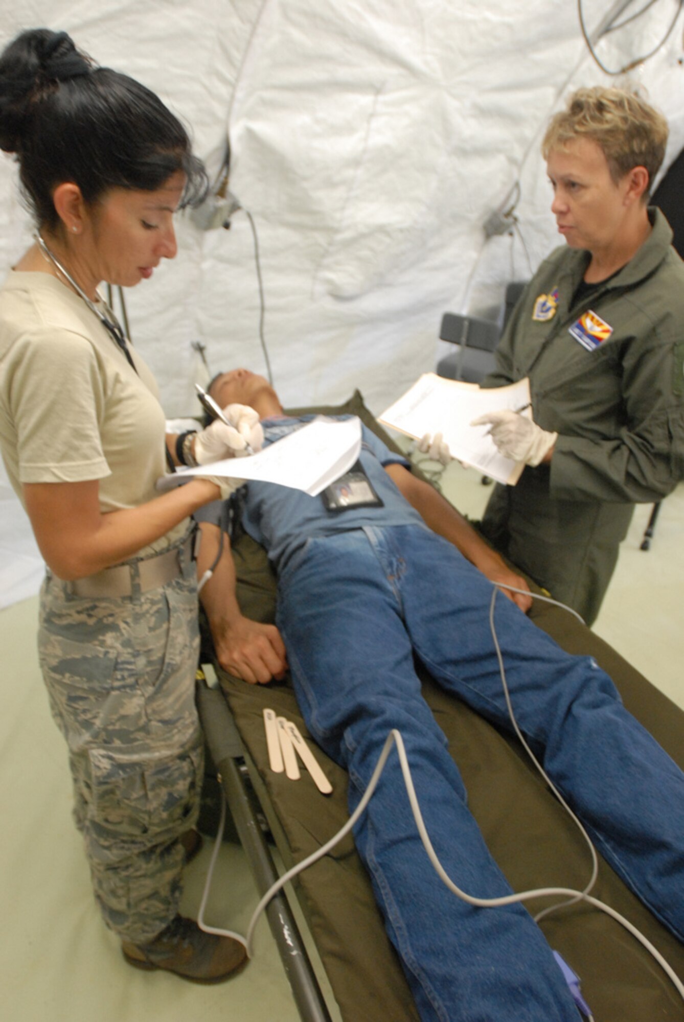 Lt. Col. Jackie Federico-Lopez, clinical nurse, 162nd Medical Group, Arizona National Guard, and Maj. Janet Campion, a flight surgeon also with the 162nd Med. Group, evaluate a victim during Vigilant Guard Guam, Aug. 24, 2010. The Airmen are part of the emergency medicine portion of the training exercise.  (U.S. Army photo by Sgt. Darron Salzer)