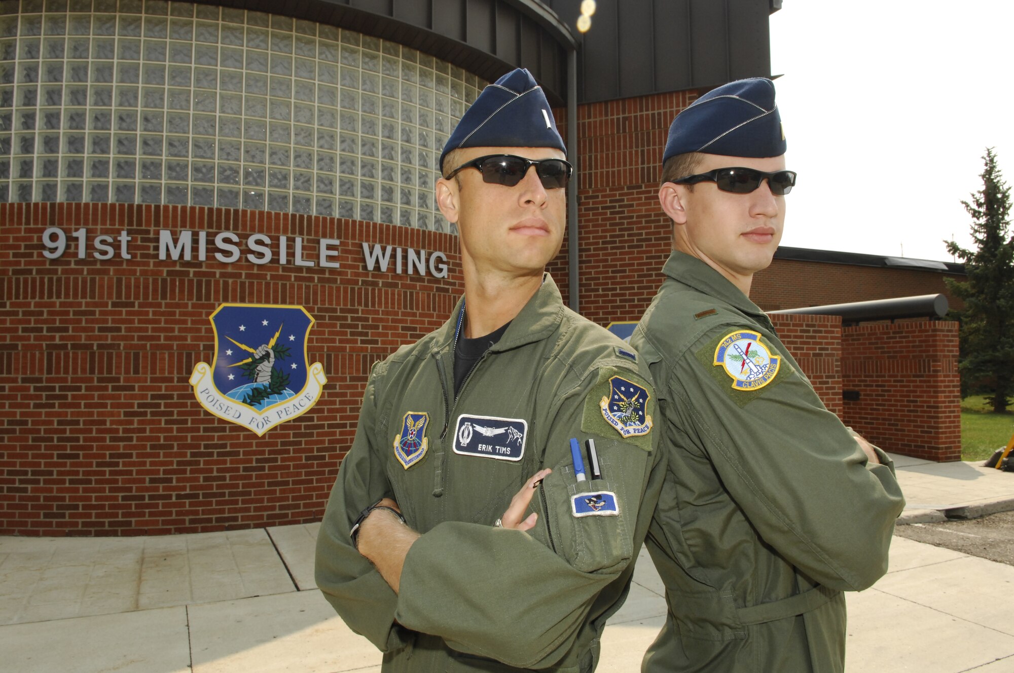 MINOT AIR FORCE BASE, N.D. -- 1st Lt. Erik Tims, 742nd Missile Squadron Missile Combat Crew Commander, and 2nd Lt. Patrick Tims, 742nd MS Deputy Missile Combat Crew Commander, pose for a photo outside of the 91st Missile Wing headquarters building Aug. 18. The two lieutenants, who happen to be brothers, took part in a once-in-a-lifetime event at Minot AFB here by pulling their first and last alert together Aug. 19. (U.S. Air Force photo by Tech. Sgt. Thomas Dow)