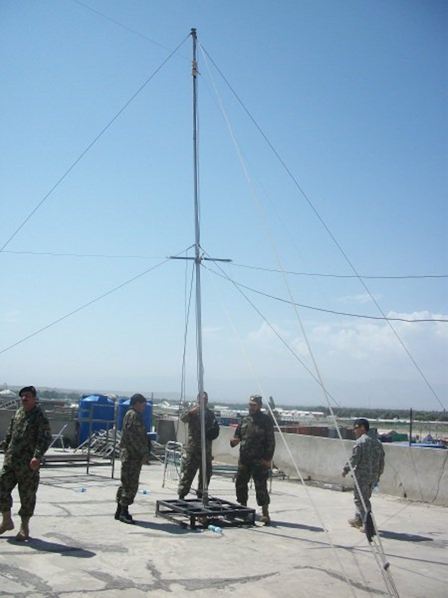 Afghan Air Force Communication squadron members erect a radio tower in Jalalabad, Afghanistan.  (U.S. Military photo/RELEASED).

