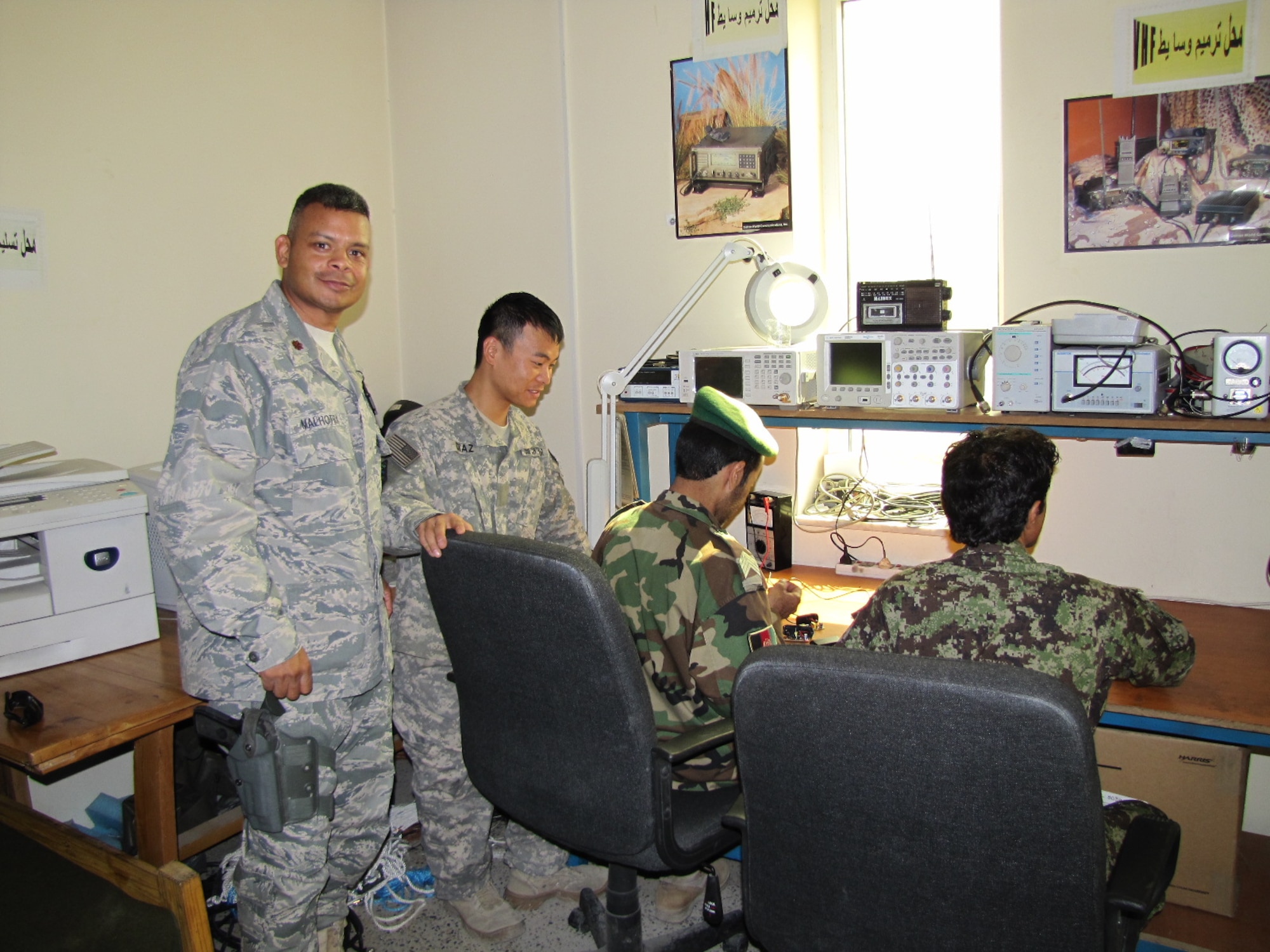 Major Sanjoy Malhotra and Mr. Al Diaz, Combined Air Power Transition Force Comm mentors pose for a photo with their Afghan counterparts on the Afghan Air Force.  (U.S. Air Force photo by Capt. Rob Leese/RELEASED).
