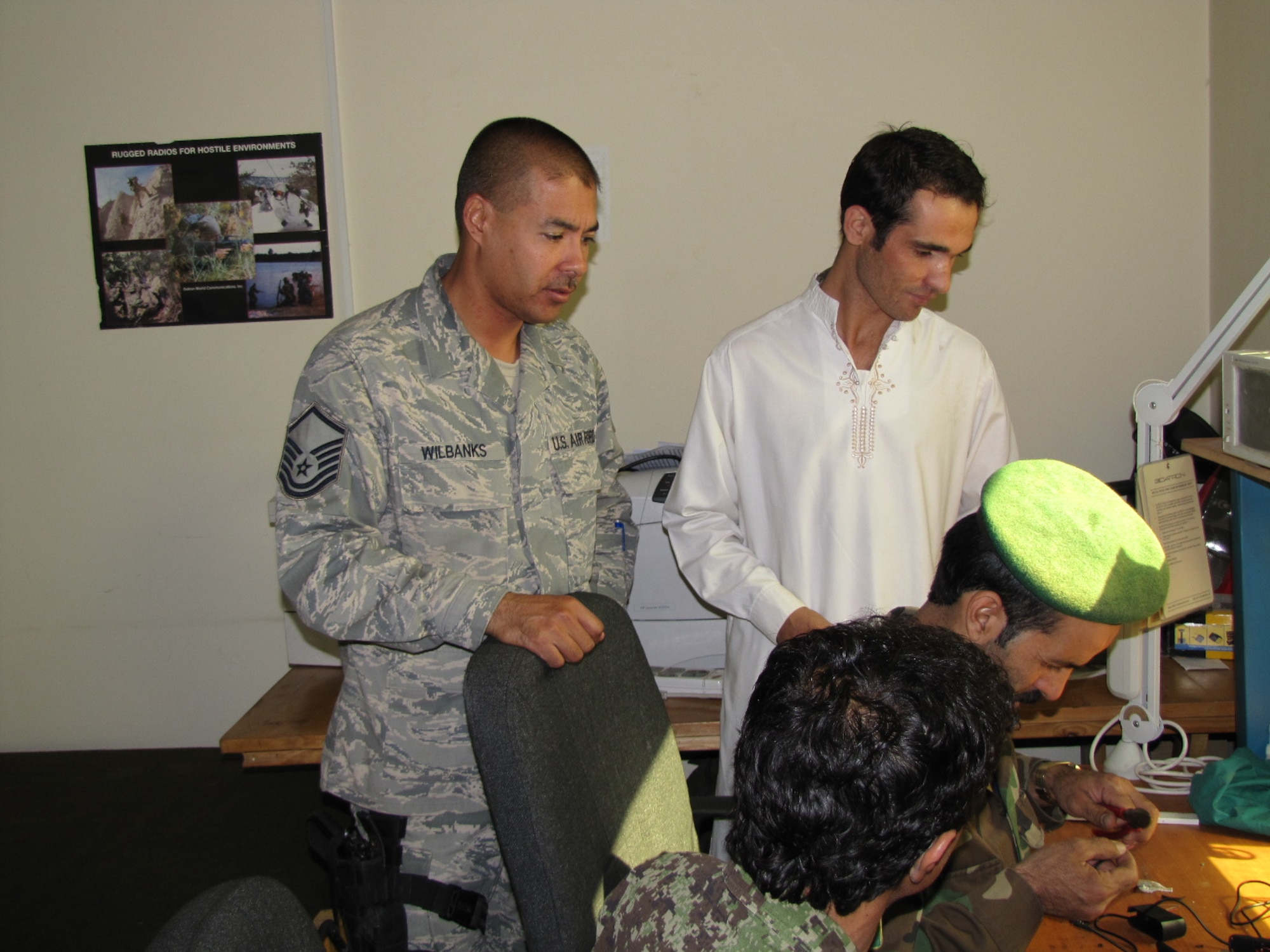 KABUL, Afghainstan -MSgt. Jack Wilbanks, a Combined Air Power Transition Force Comm mentor watches as his Afghan counterparts work on a radio on the Afghan Air Force.  (U.S. Air Force photo by Capt. Rob Leese/RELEASED).